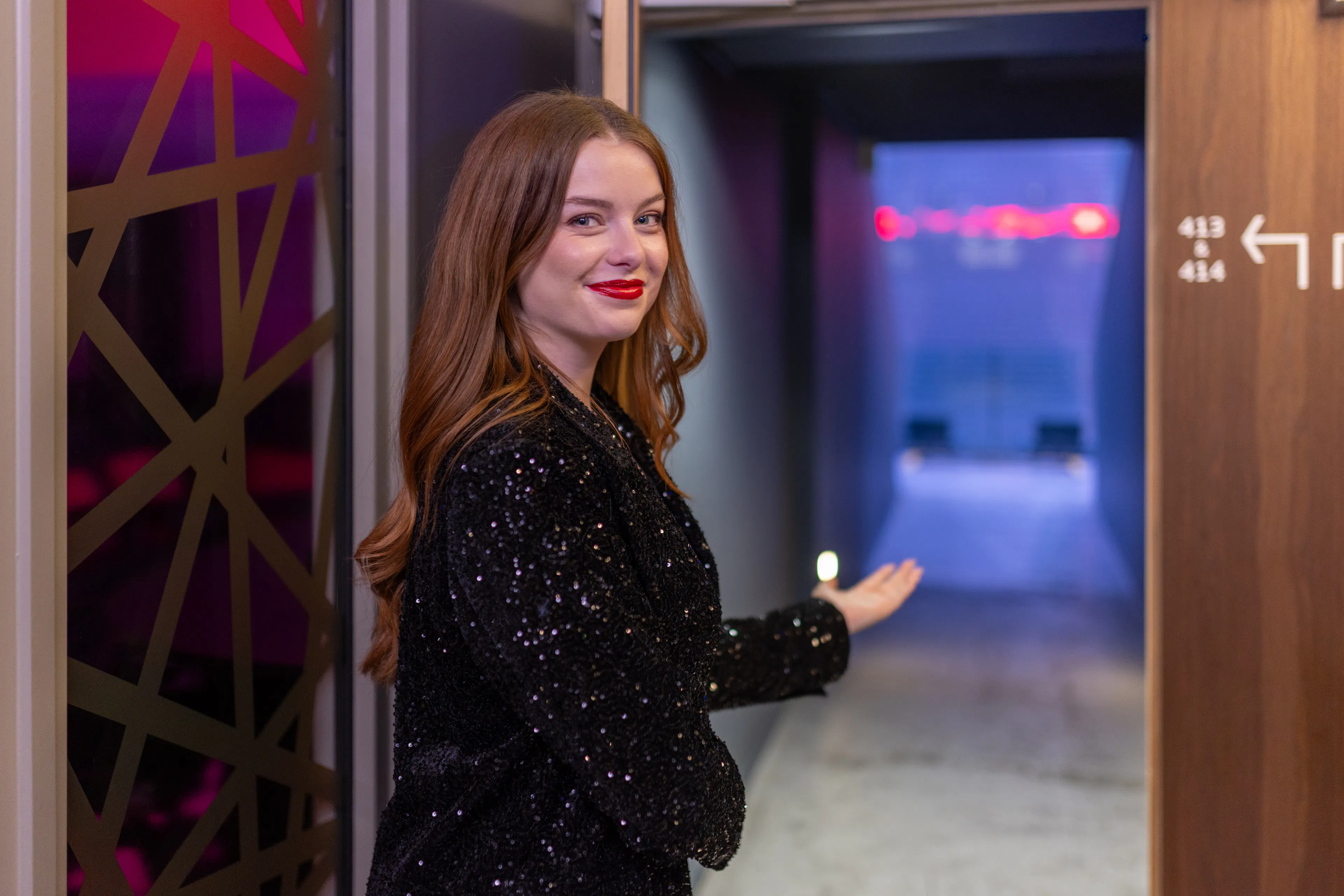 Une hôtesse accueillant des visiteurs devant une arena