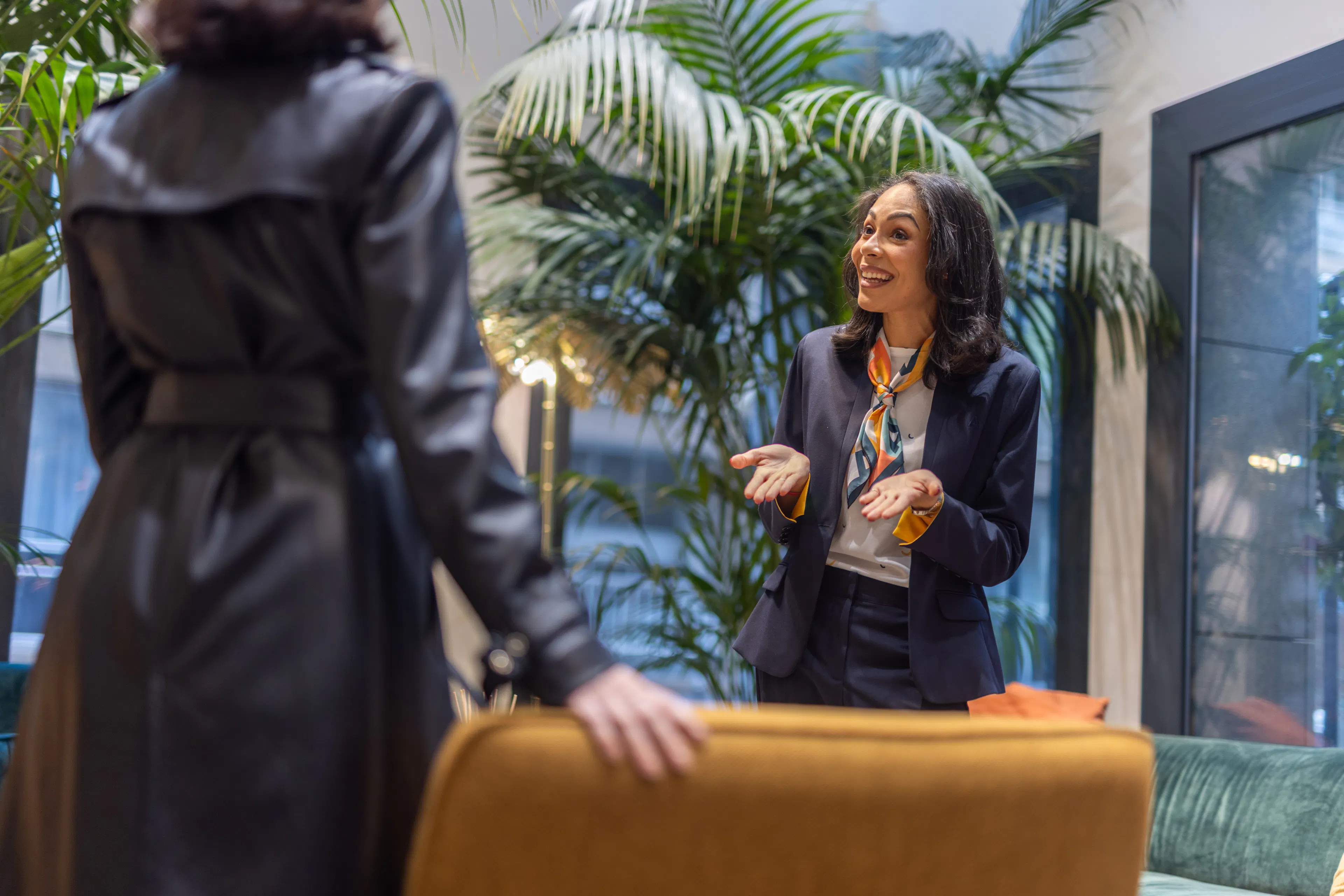 Une hôtesse d'accueil à l'accueil d'une entreprise accueillant un visiteur