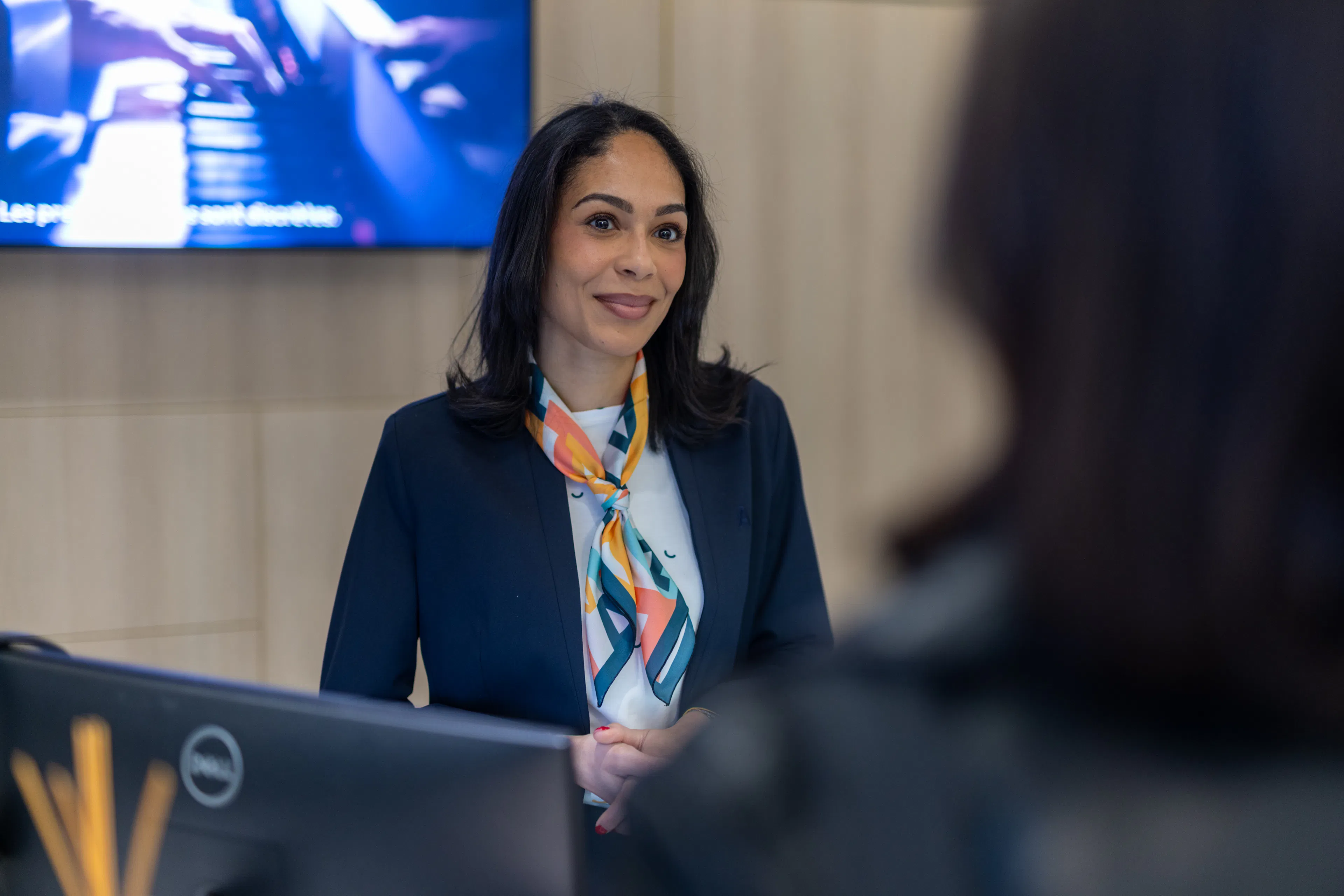 Une hôtesse accueillant un visiteur à l'accueil d'une entreprise