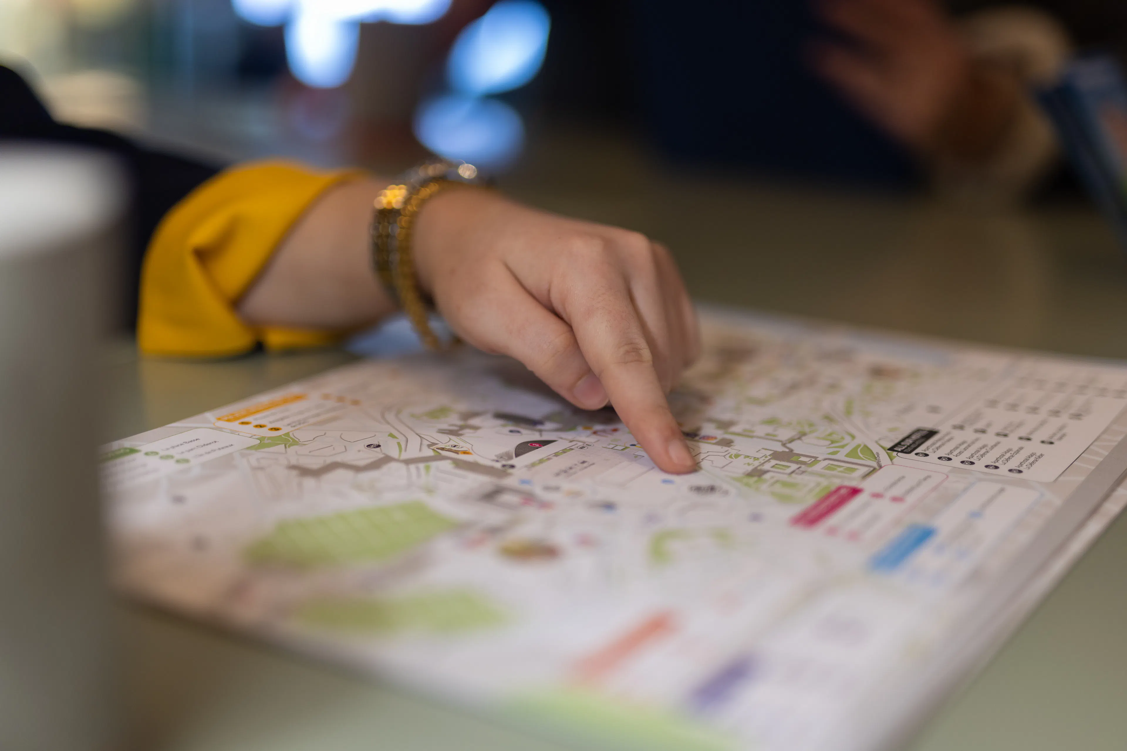 Une hôtesse d'accueil transmettant des informations sur l'orientation du centre commercial à un visiteur