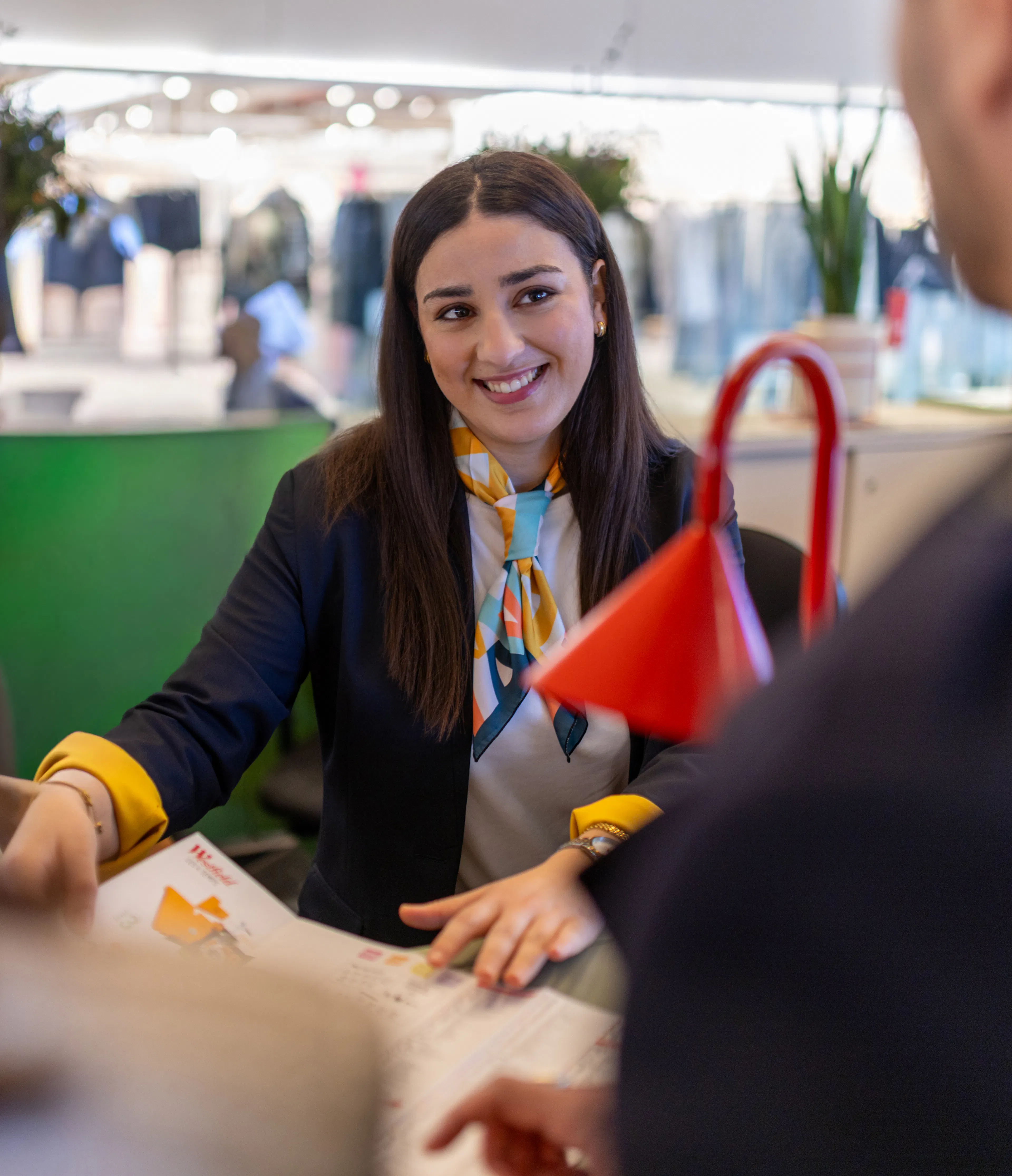 Une hôtesse d'accueil transmettant des informations sur l'orientation du centre commercial