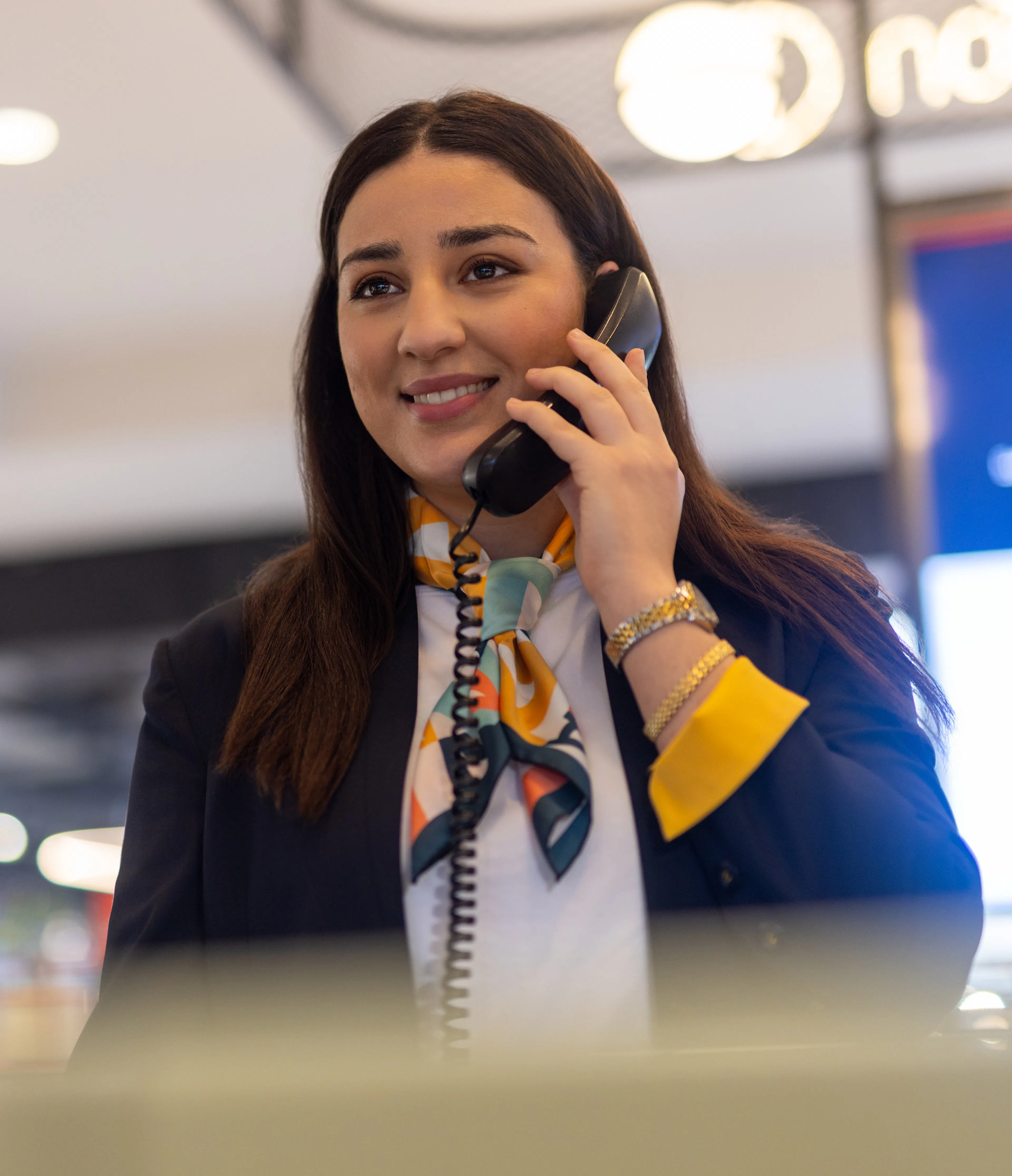 Une hôtesse d'accueil au téléphone dans un centre commercial