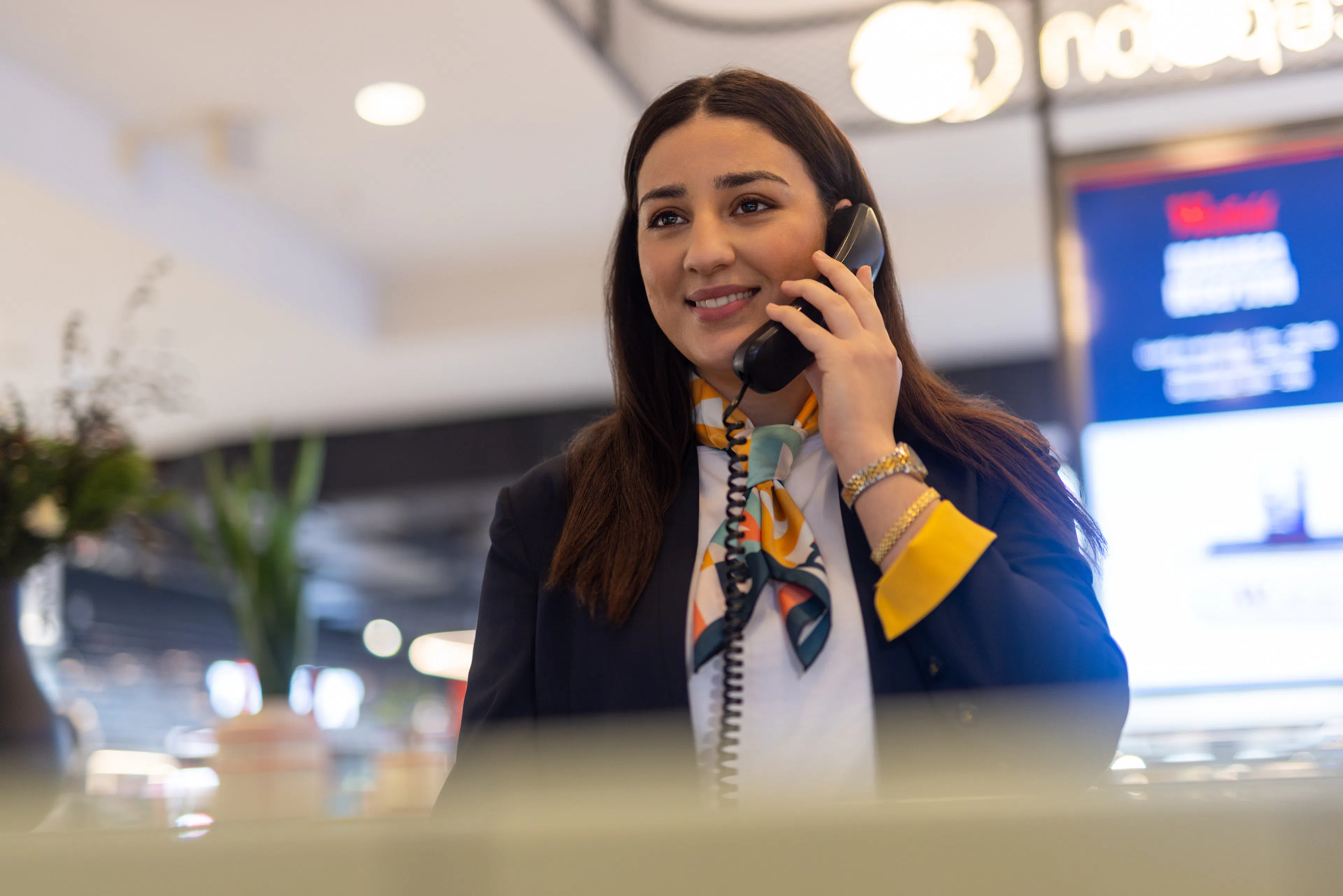 Une hôtesse d'accueil au téléphone à l'accueil d'un centre commercial