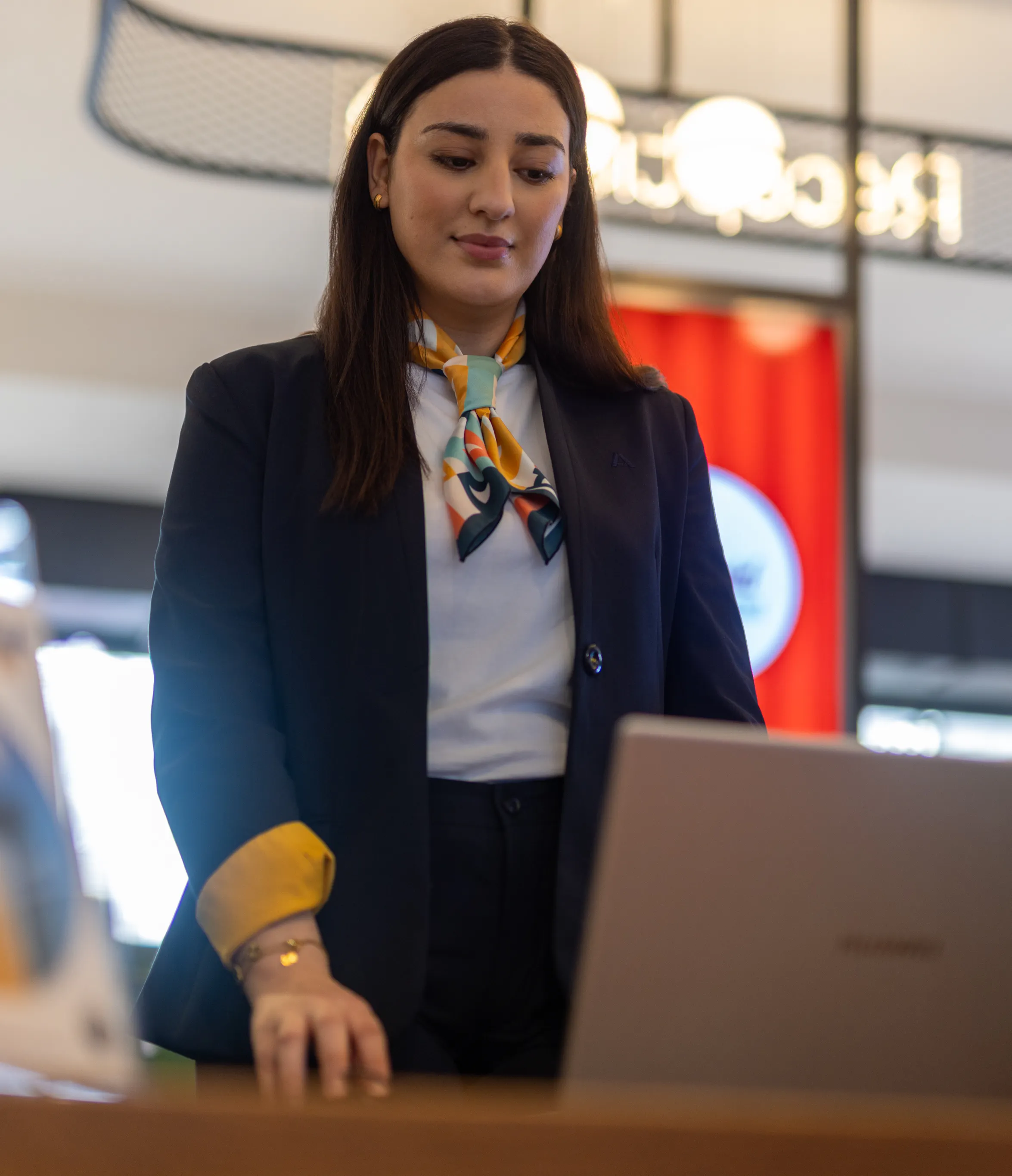 Une hôtesse d'accueil sur son ordinateur portable à l'accueil d'un centre commercial