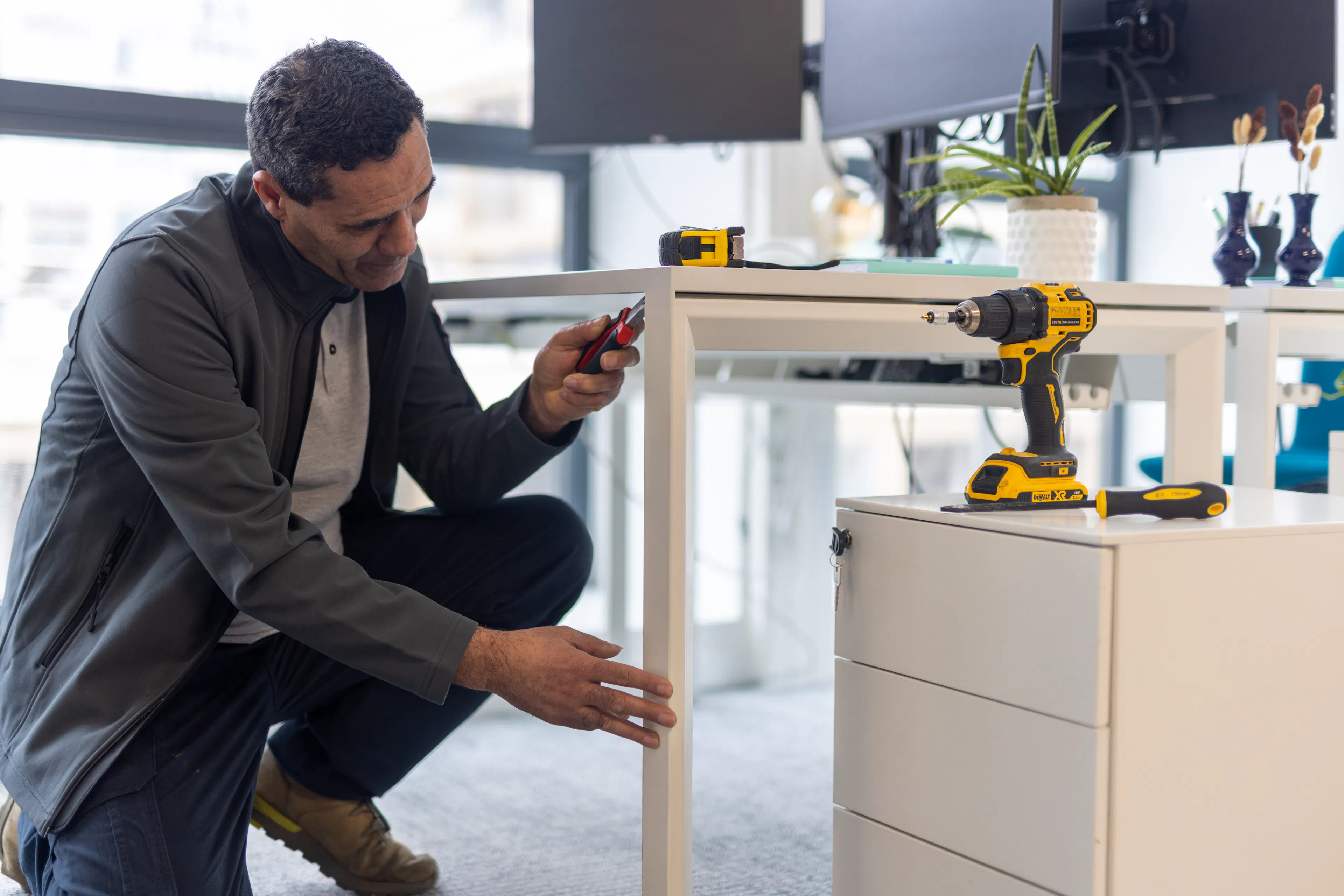Un agent de maintenance réparant un bureau dans un environnement de travail