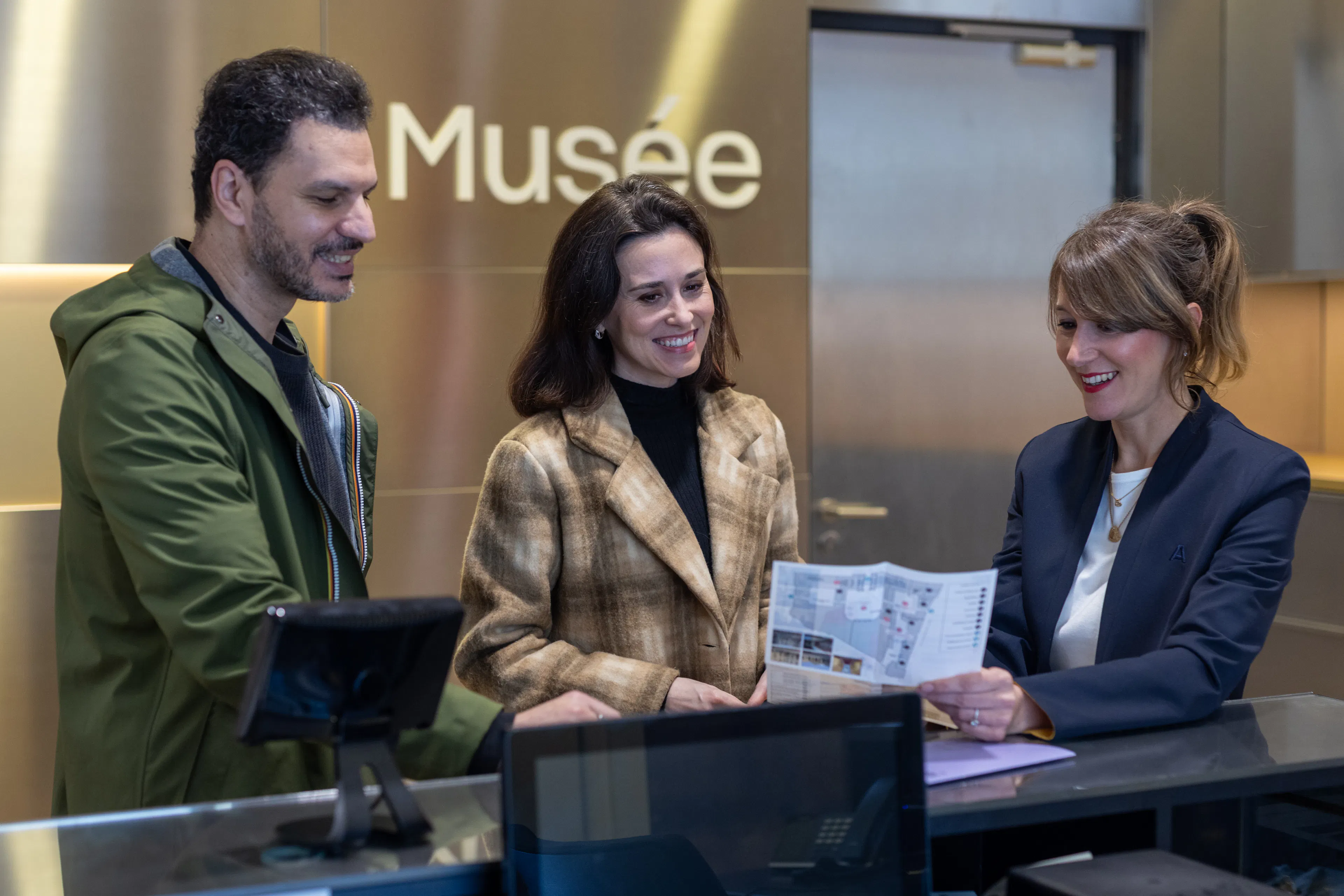 Un agent d'accueil dans un musée donnant des informations à des visiteurs 