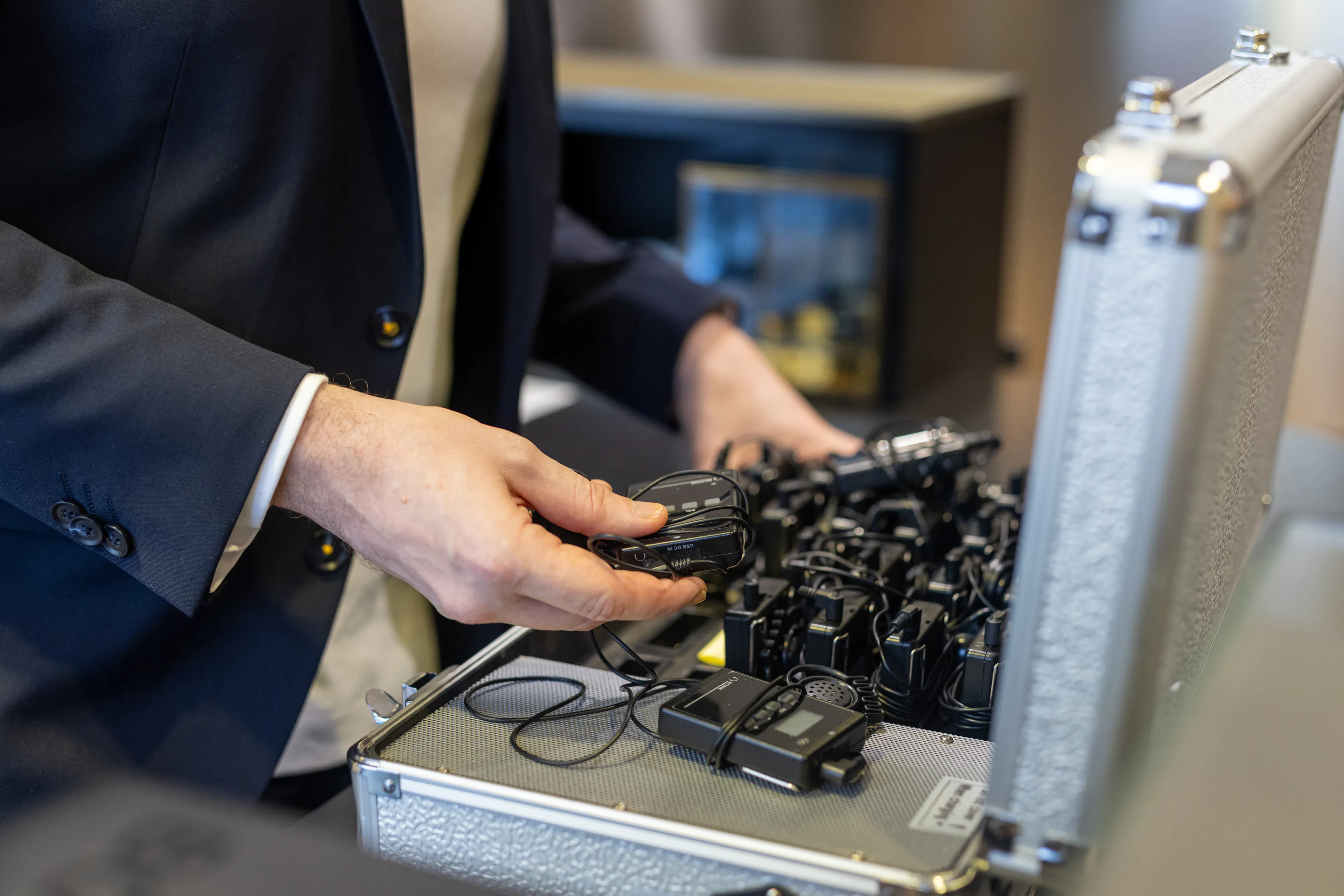 Un médiateur rangeant des audio guides dans son étui