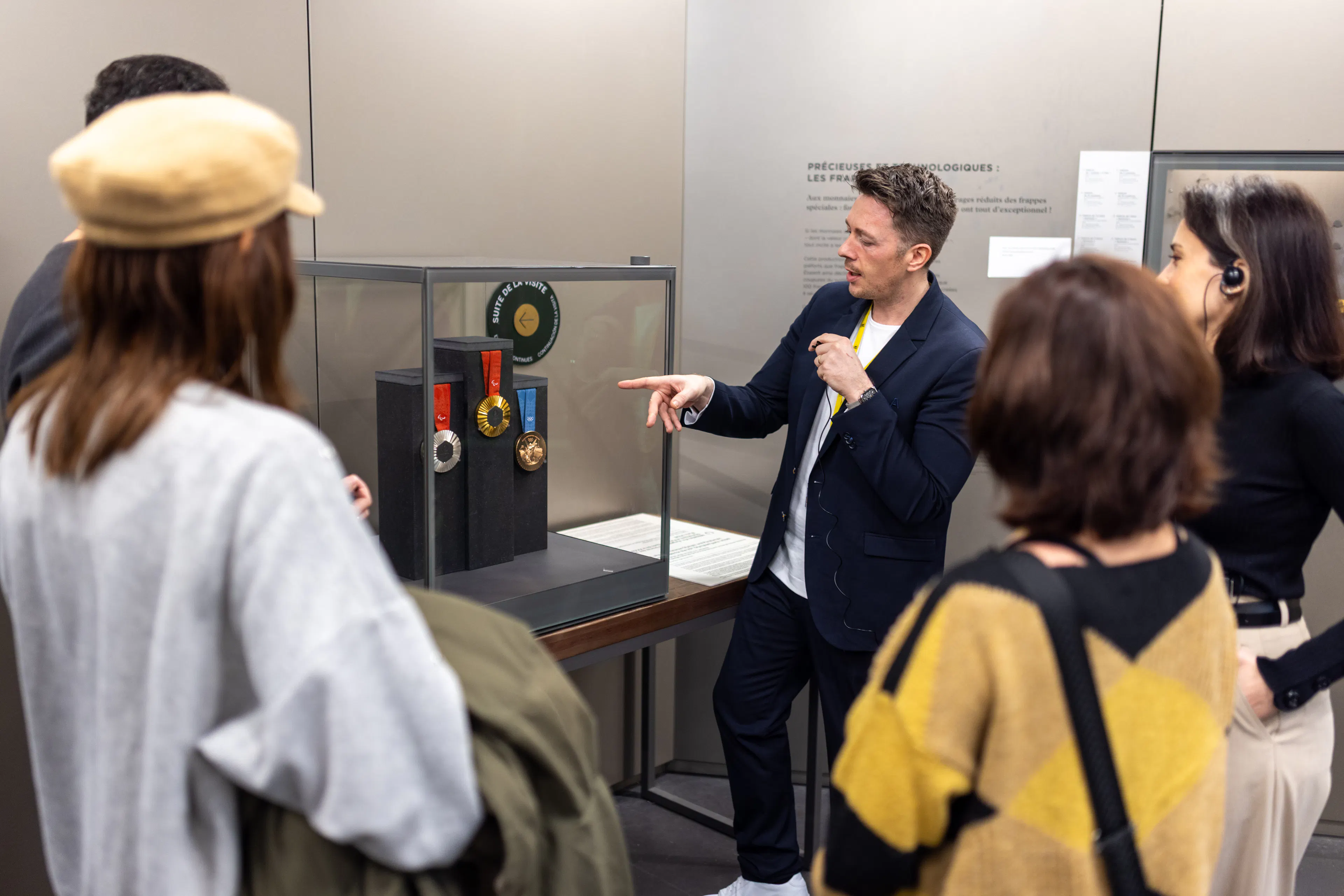 Un médiateur lors d'une exposition avec des visiteurs dans un musée