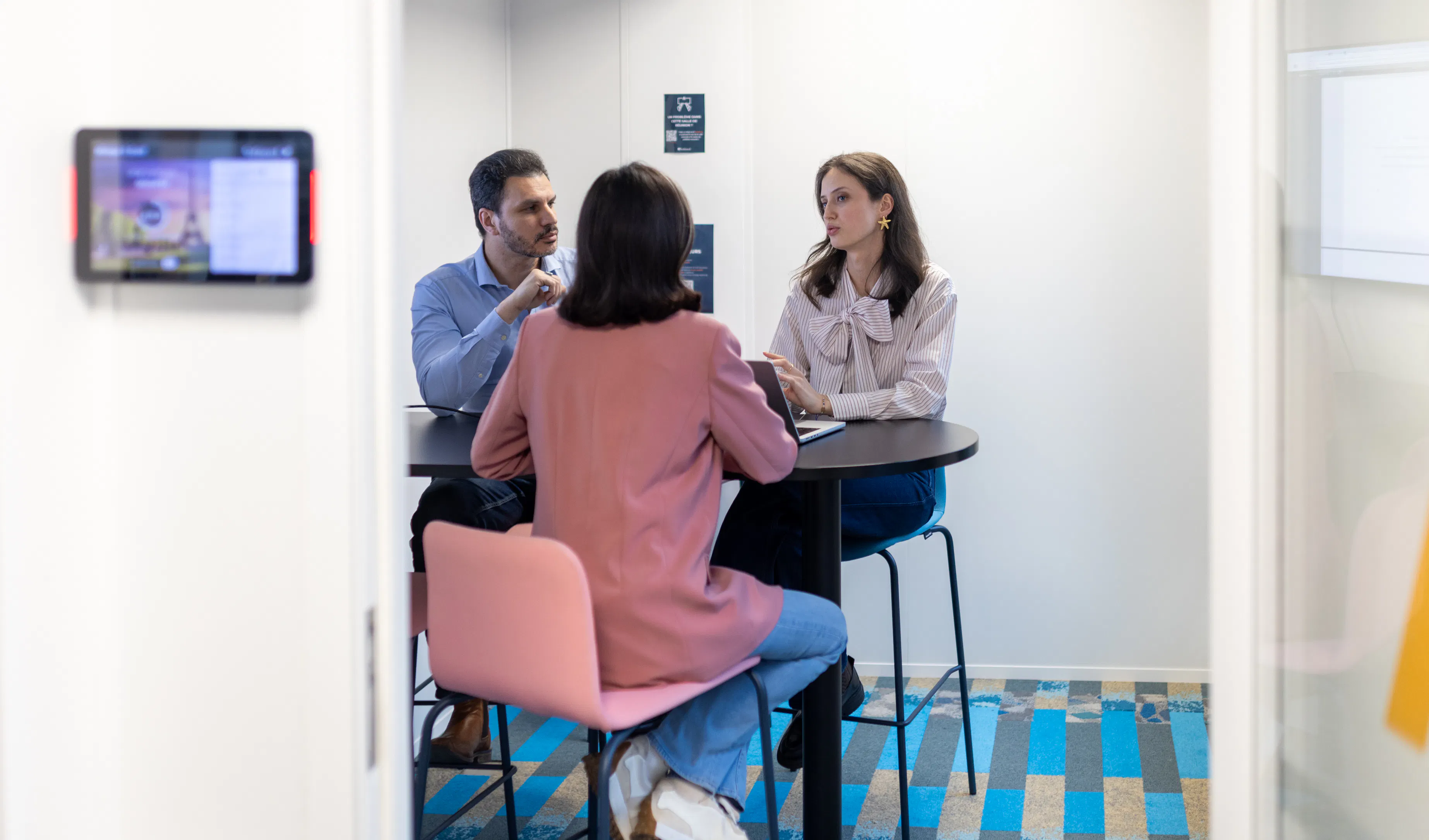 Trois collaborateurs échangeant autour d'une table