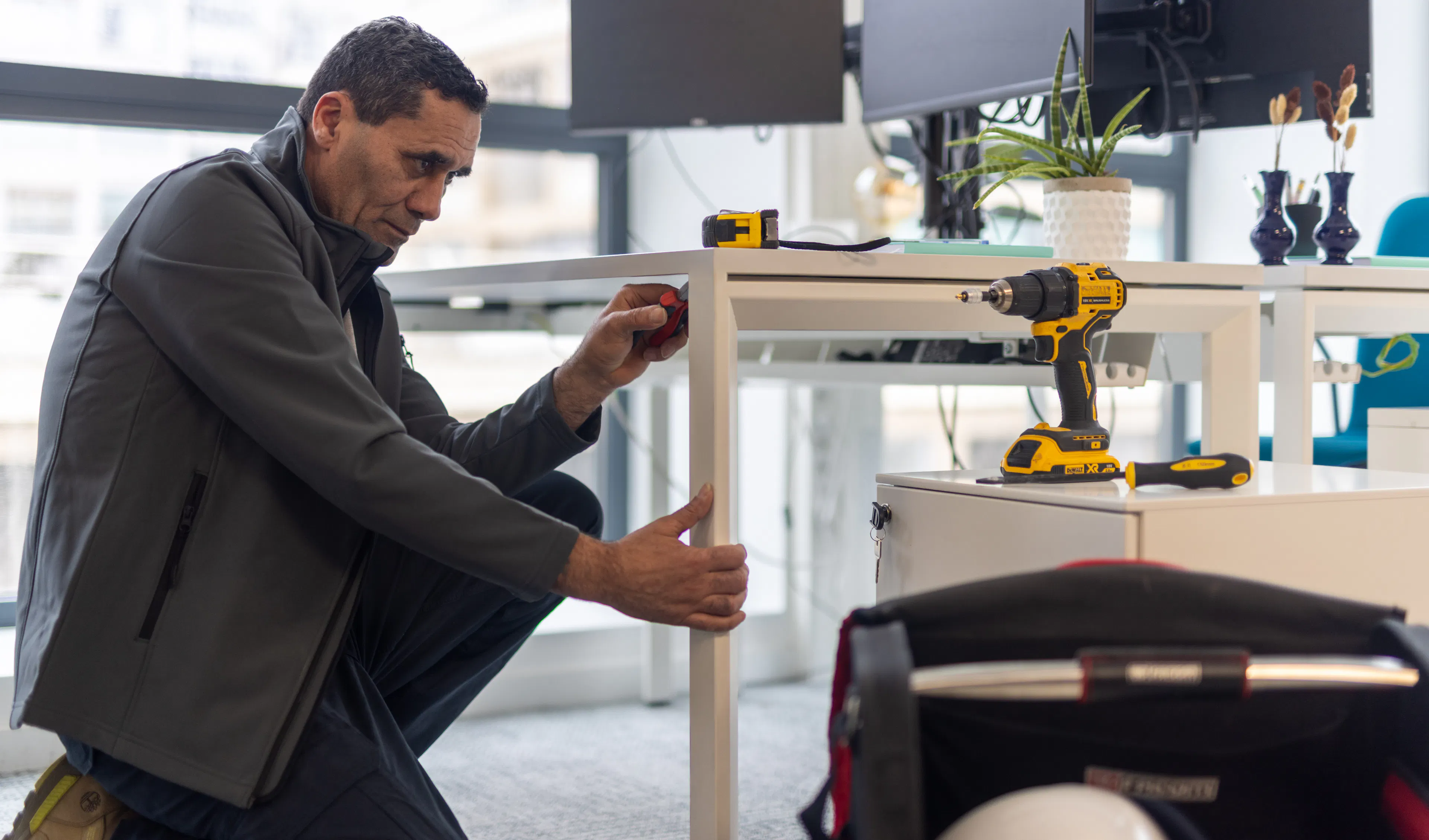 Un agent de maintenance répare un bureau dans un environnement de travail