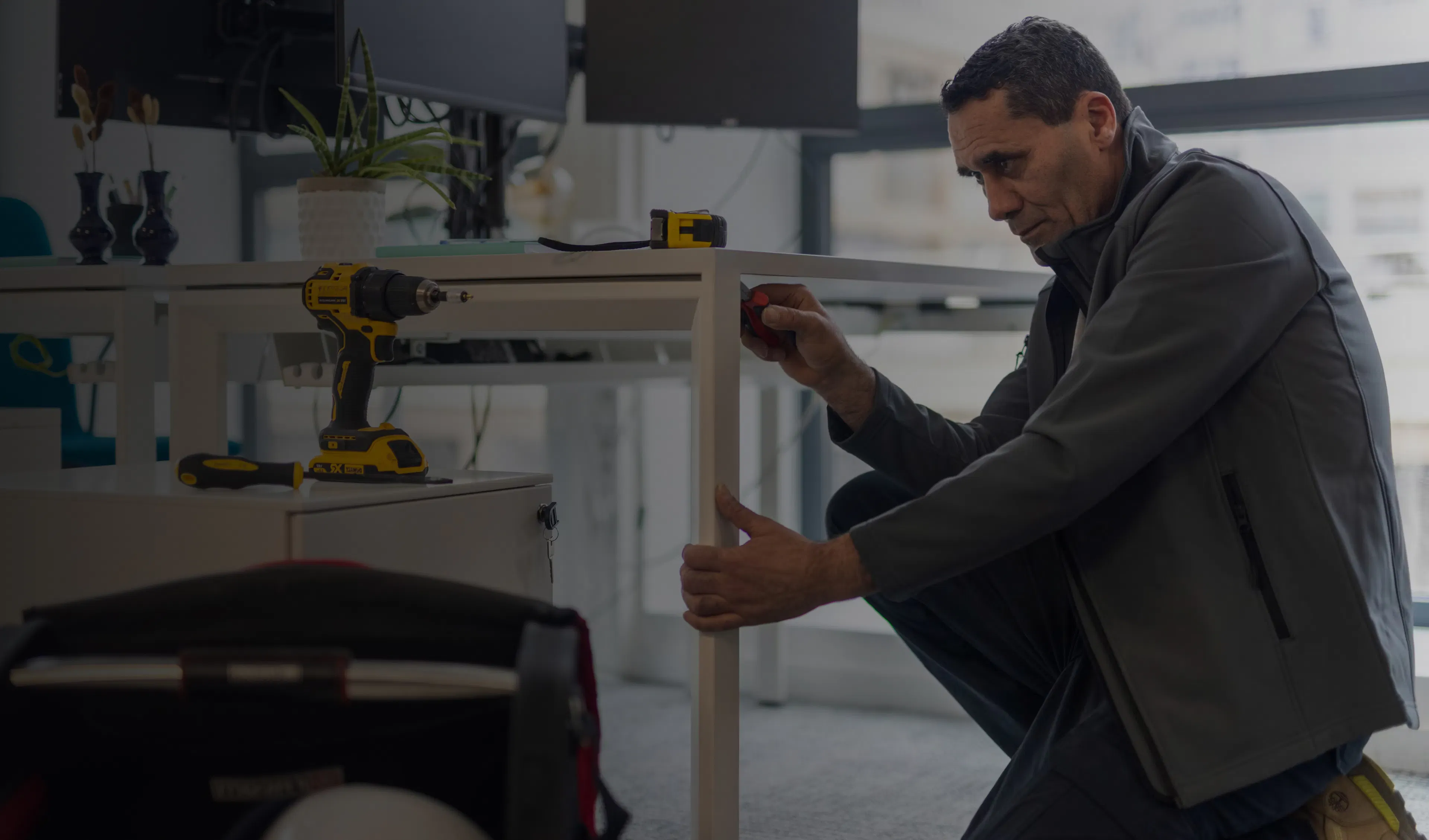 un agent de maintenance réparant un bureau