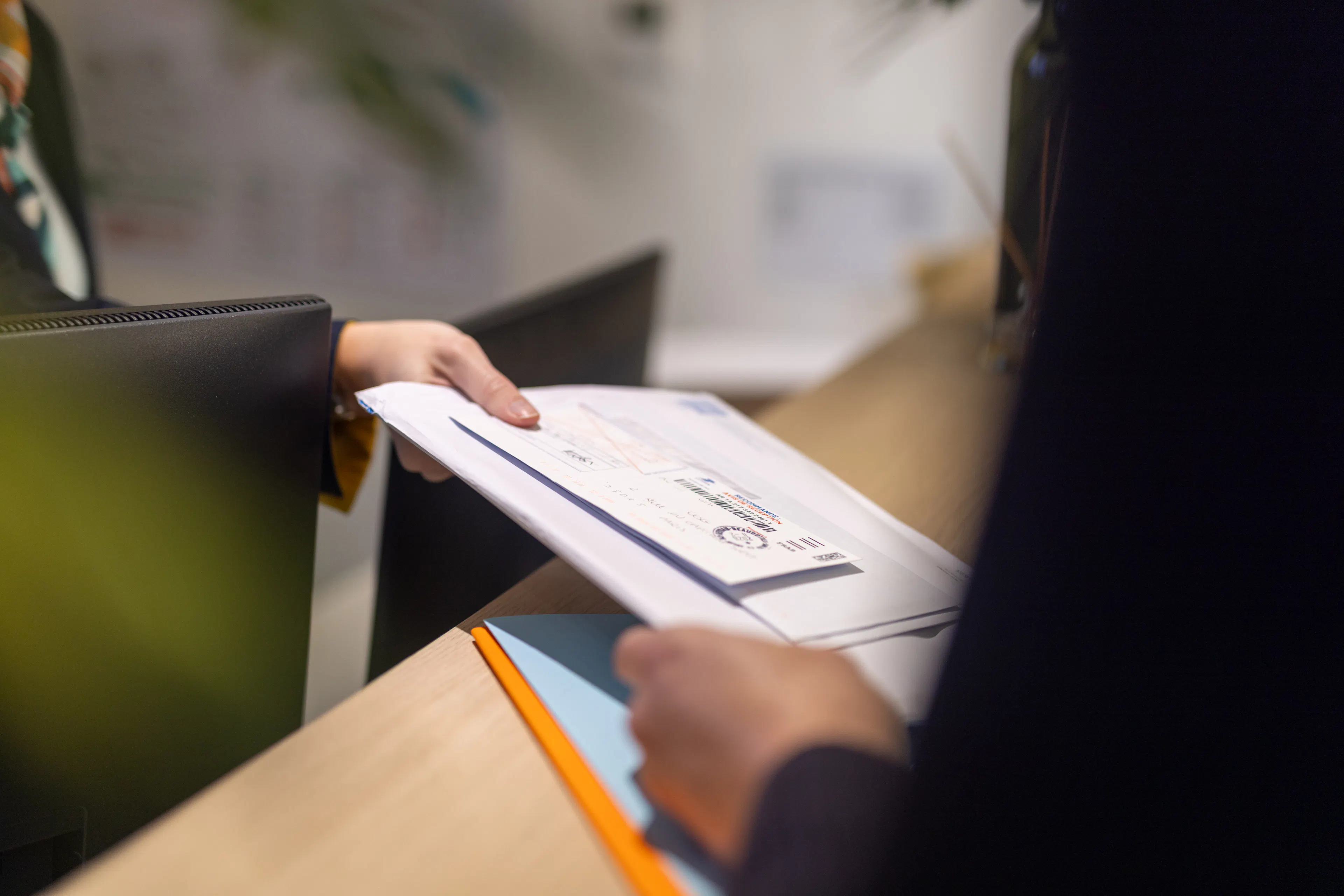 Une hôtesse remettant du courrier à un collaborateur