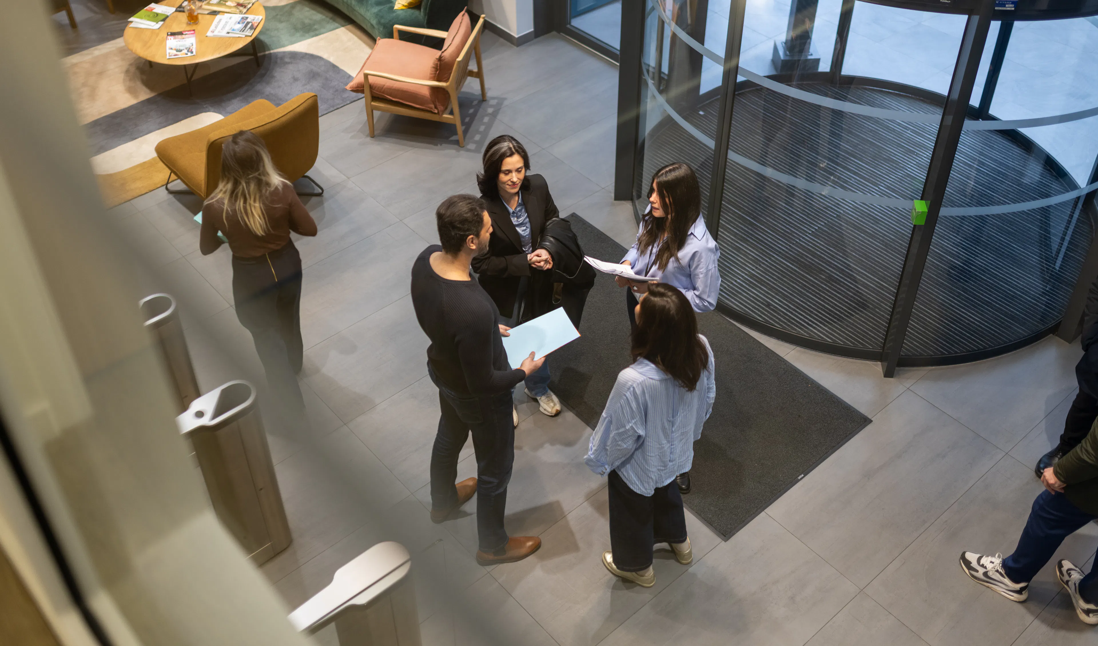4 collaborateurs échangeant à l'accueil d'un environnement de travail