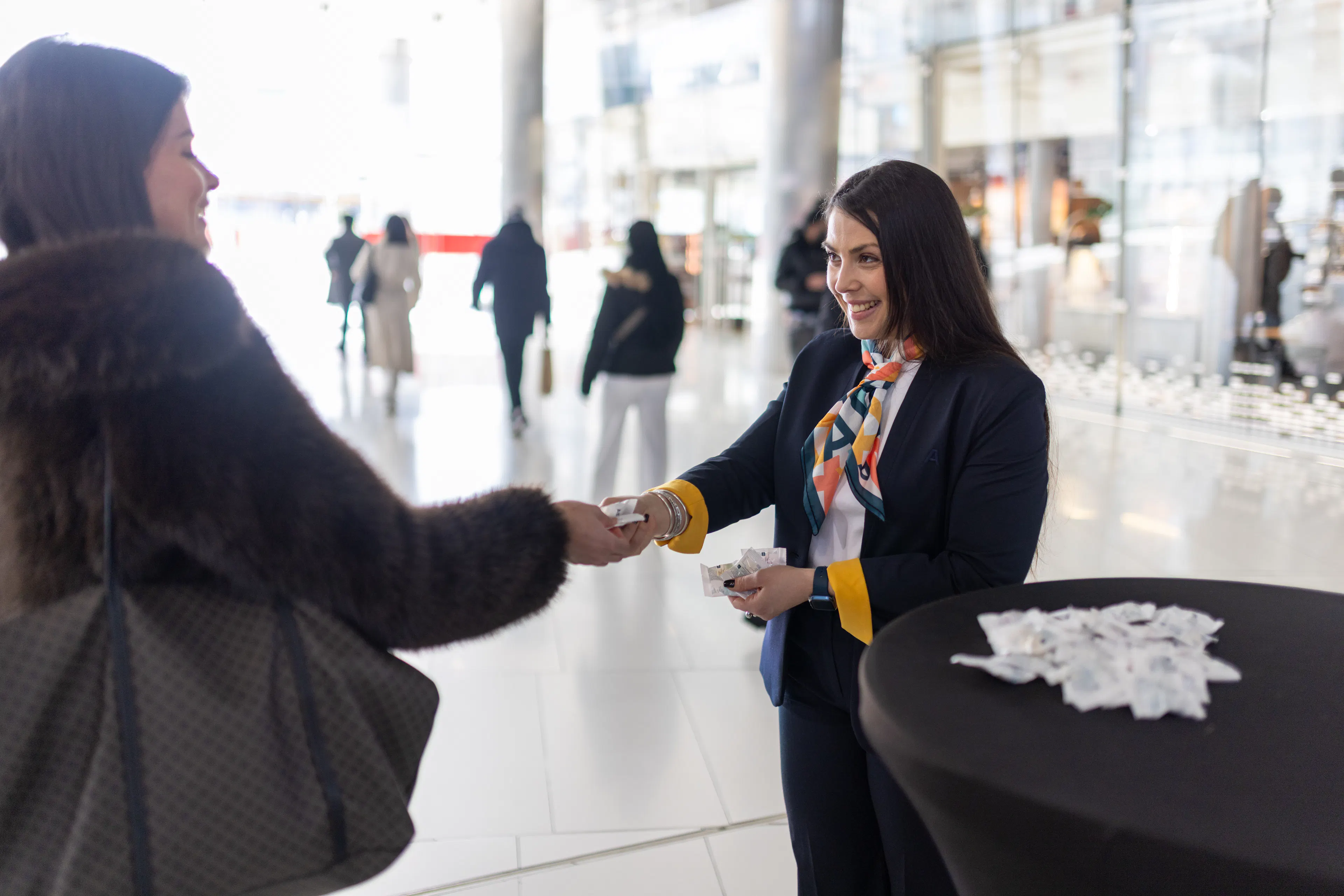 Une hôtesse d'accueil souriant à un visiteur dans un centre de shopping