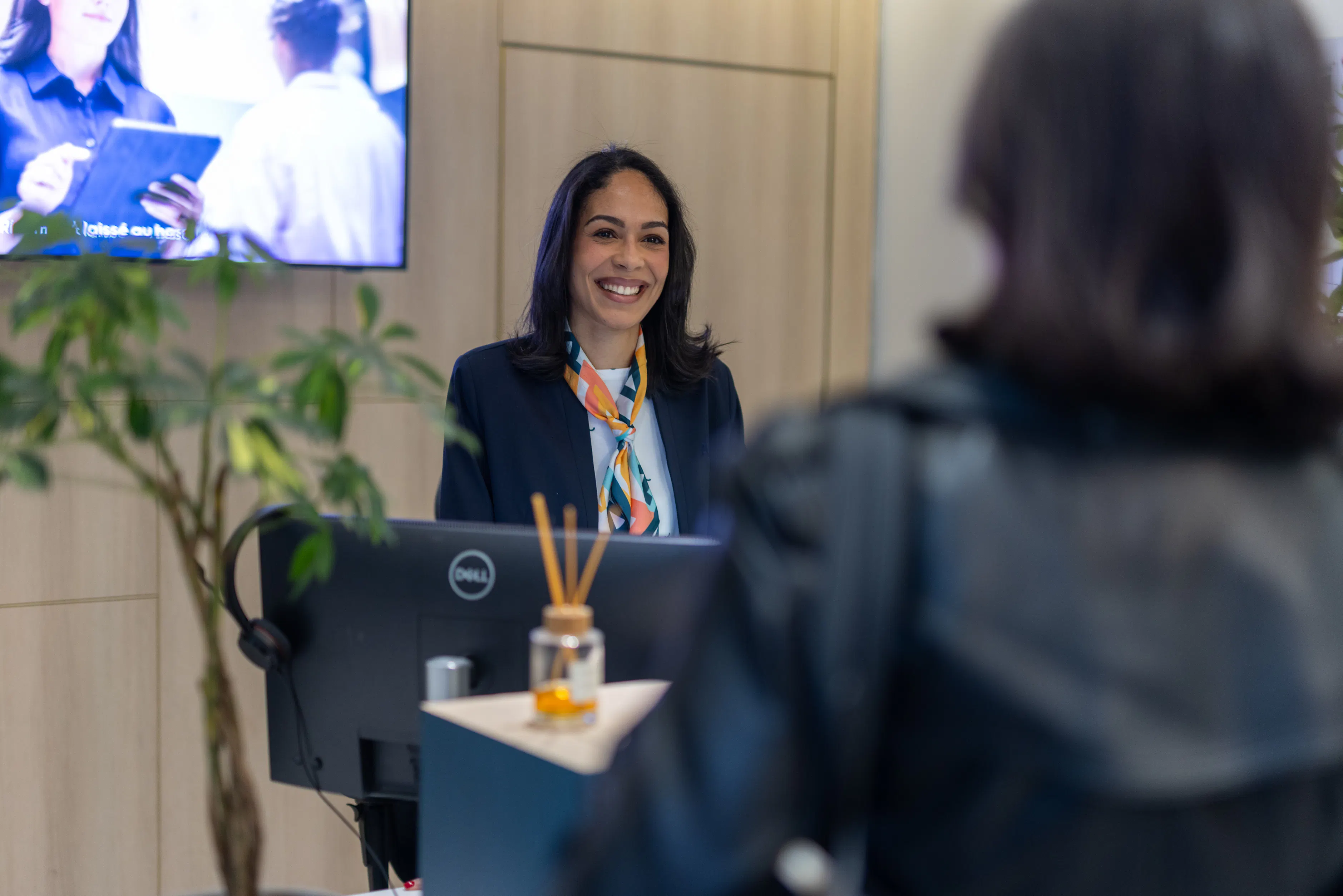 Une hôtesse d'accueil accueillant un visiteur au sein d'un environnement de travail