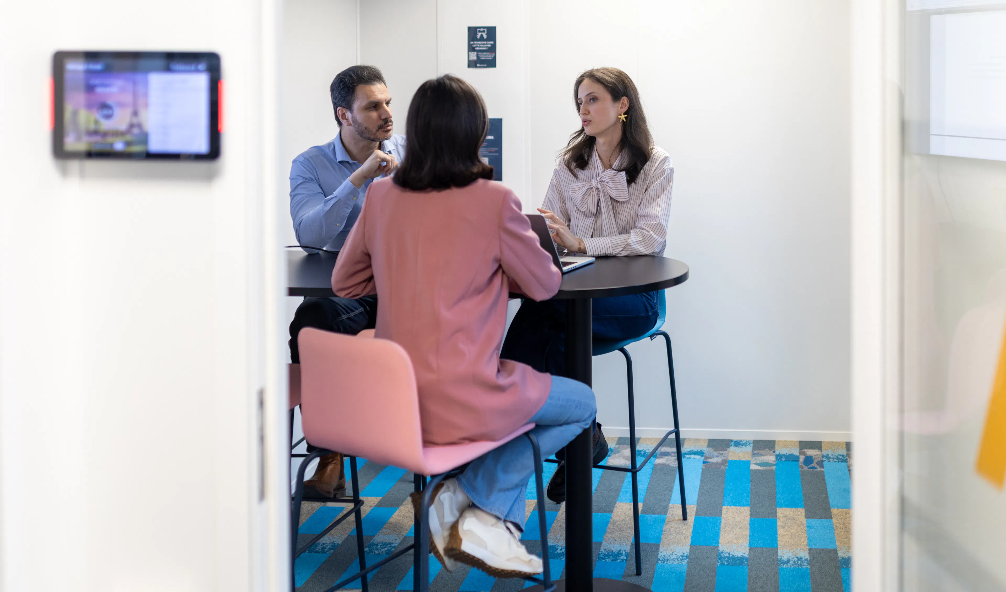 Trois collaborateurs échangeant autour d'une table
