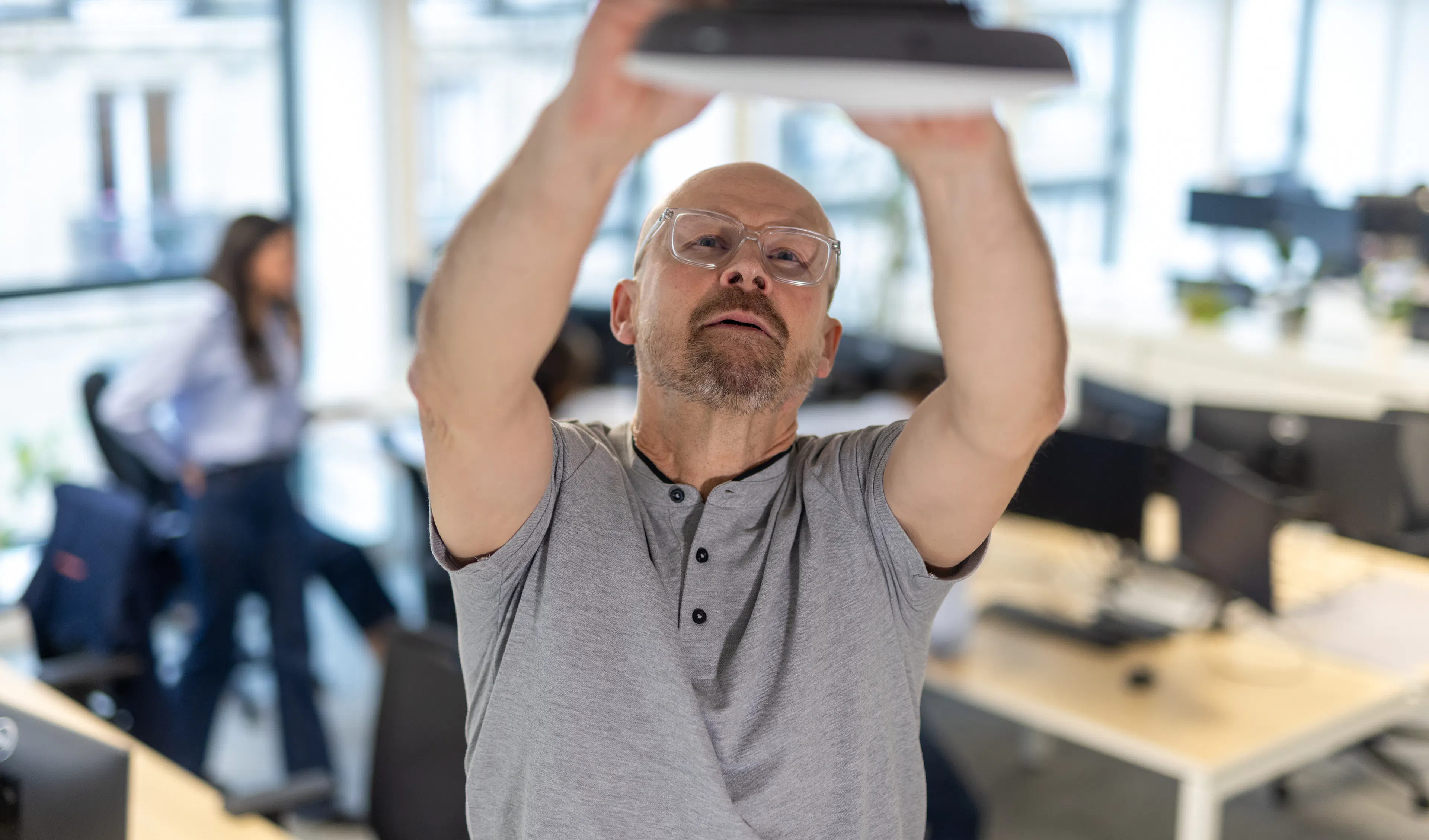 Un factotum réparant une box wifi au sein d'un environnement de travail