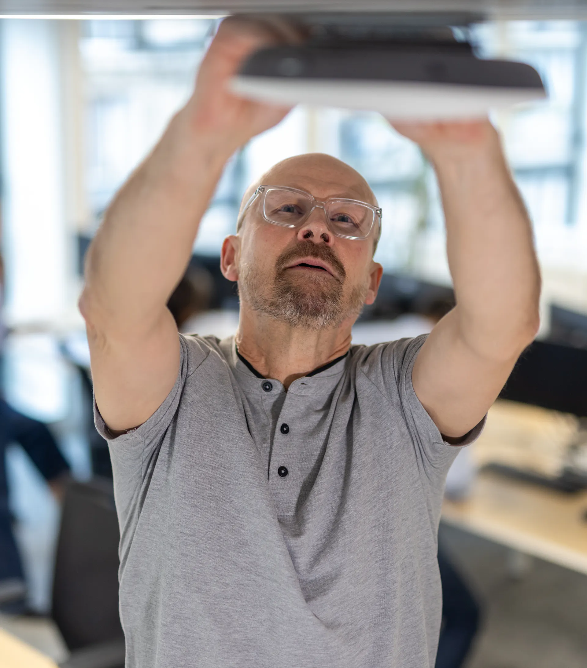 Un factotum réparant une box wifi au sein d'un environnement de travail