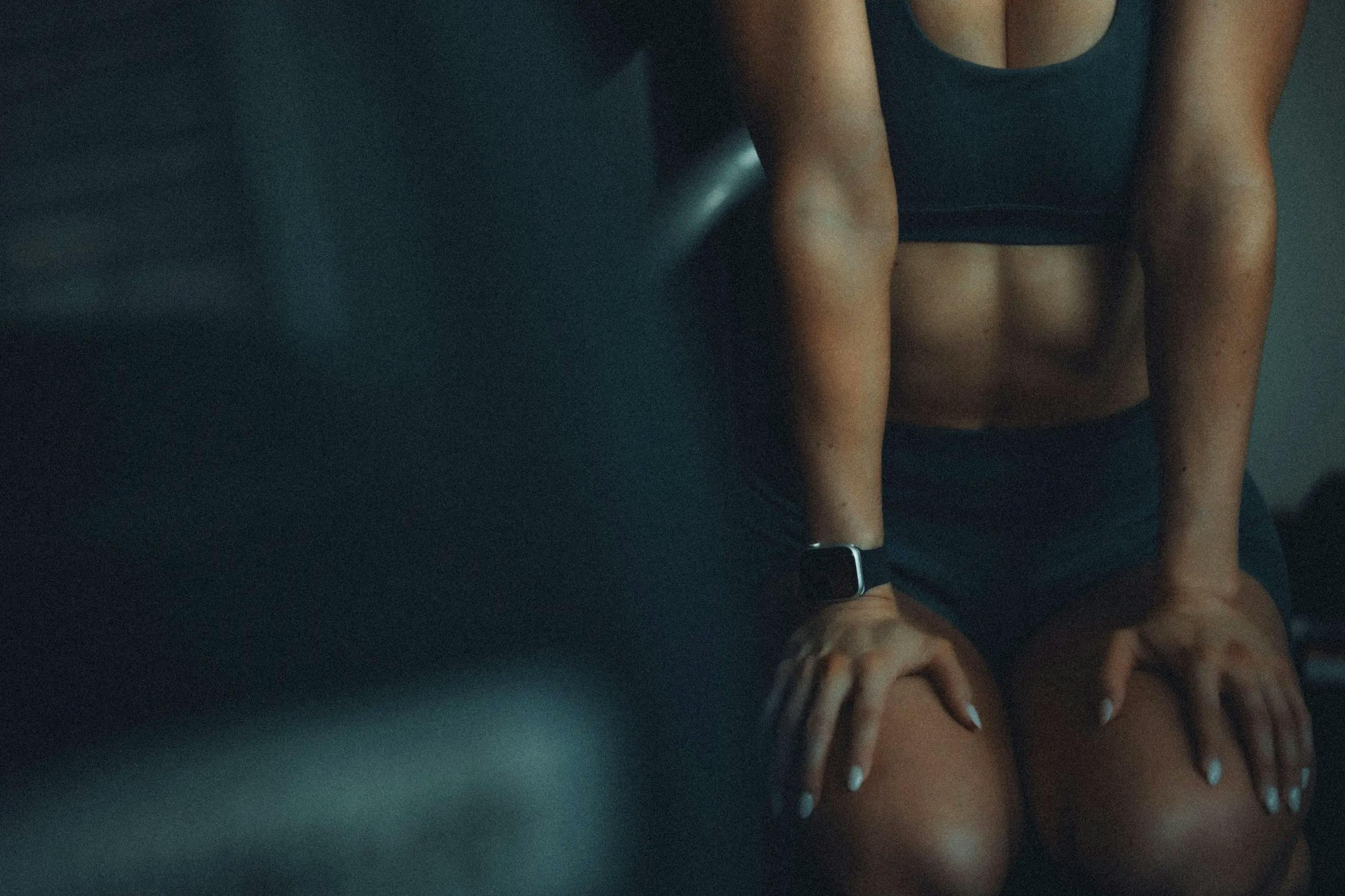 Photographie d'une personne assise sur les genoux, après une séance de sport.
