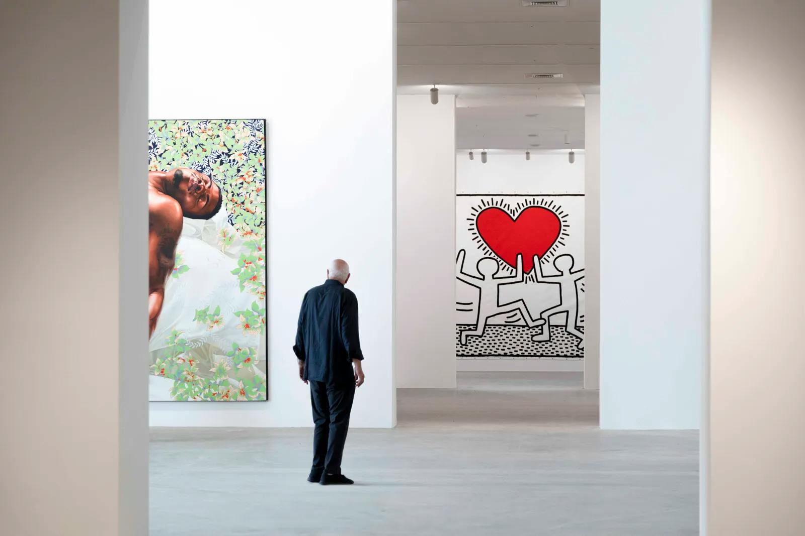 Don Rubell with Sleep (2008) by Kehinde Wiley, and Untitled (1981) by Keith Haring.
