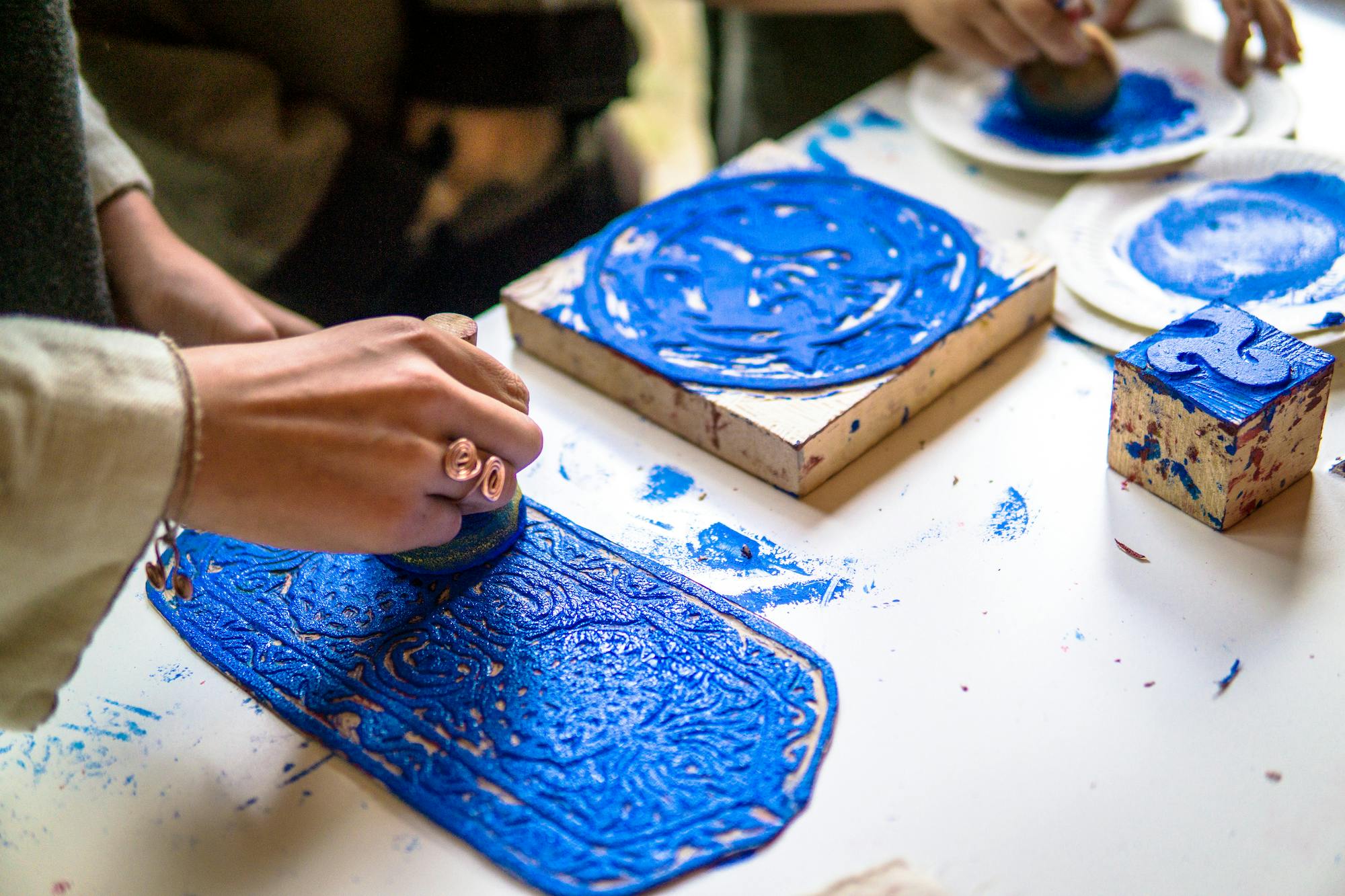 Someone showing the woodcut process of printmaking.