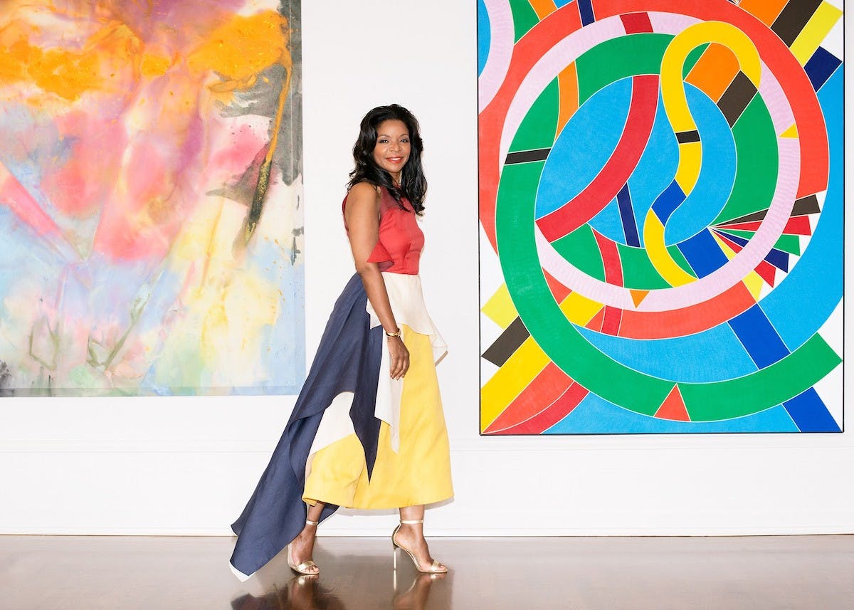 Pamela J. Joyner in front of After Glow (1972) by Sam Gilliam and Eastern Star (1971) by William T. Williams.