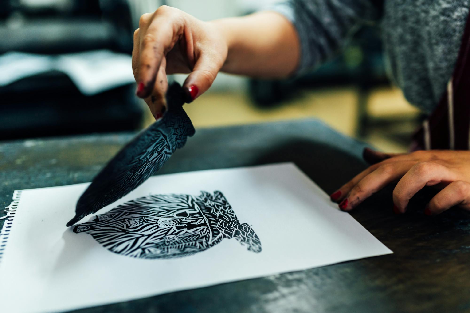 Someone showing the engraving process of printmaking.