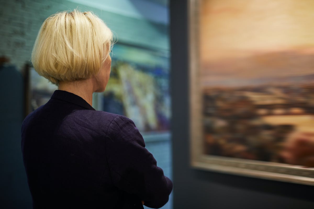 An art appraiser looking at a painting.