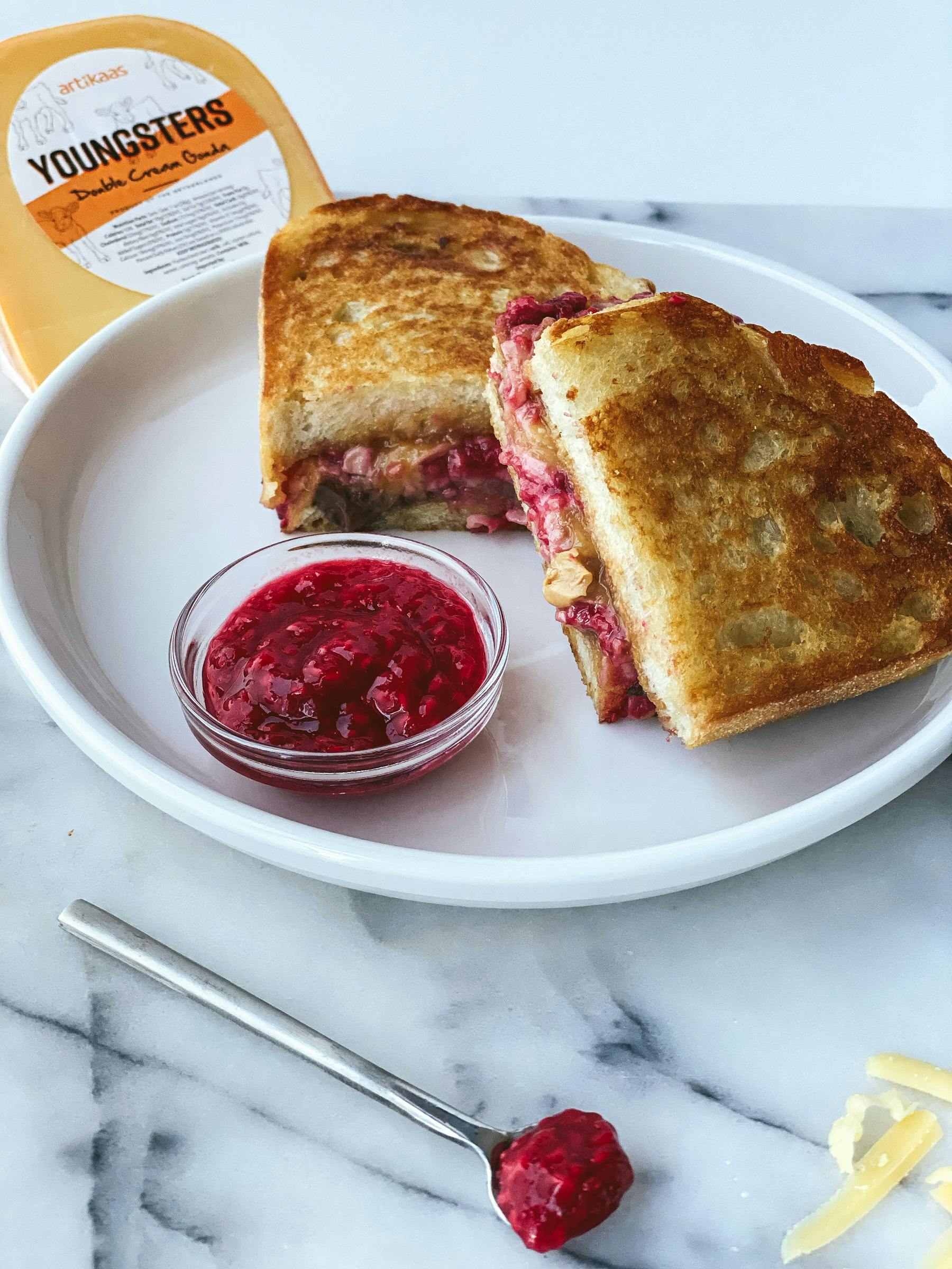 Sweet and Savory Grilled Cheese with Peanut Butter, Chocolate Hazelnut Spread, Homemade Raspberry Spread, and Artikaas Youngsters Double Cream Gouda.