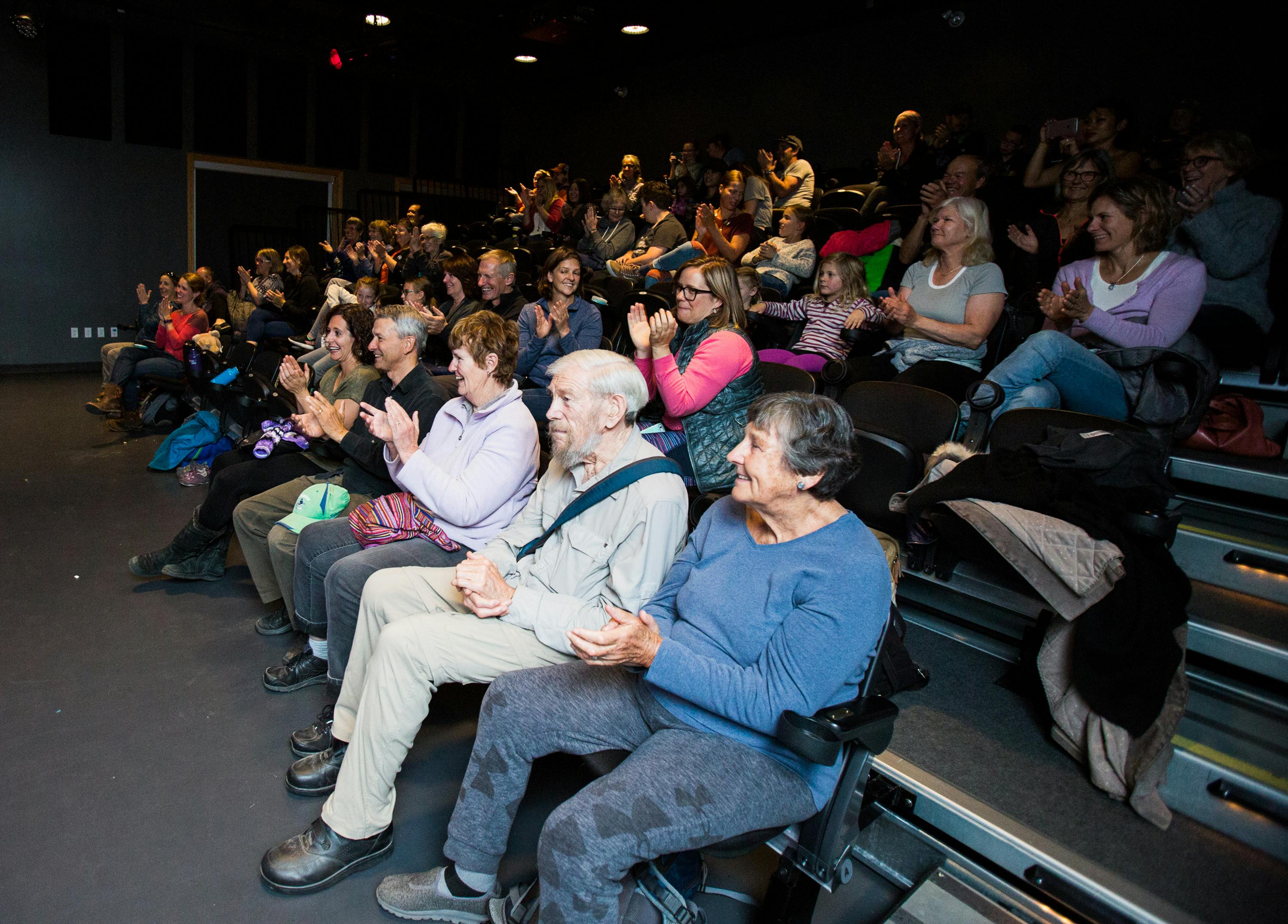 audience members clap during a screening in the movie theatre