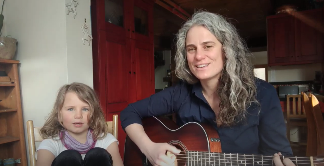 Ellen Braun with daughter singing and playing guitar
