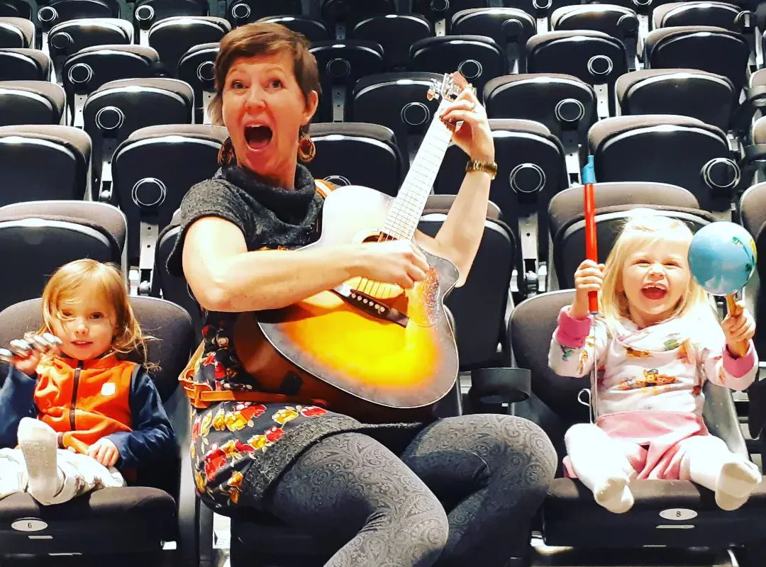 a woman and two kids playing instruments
