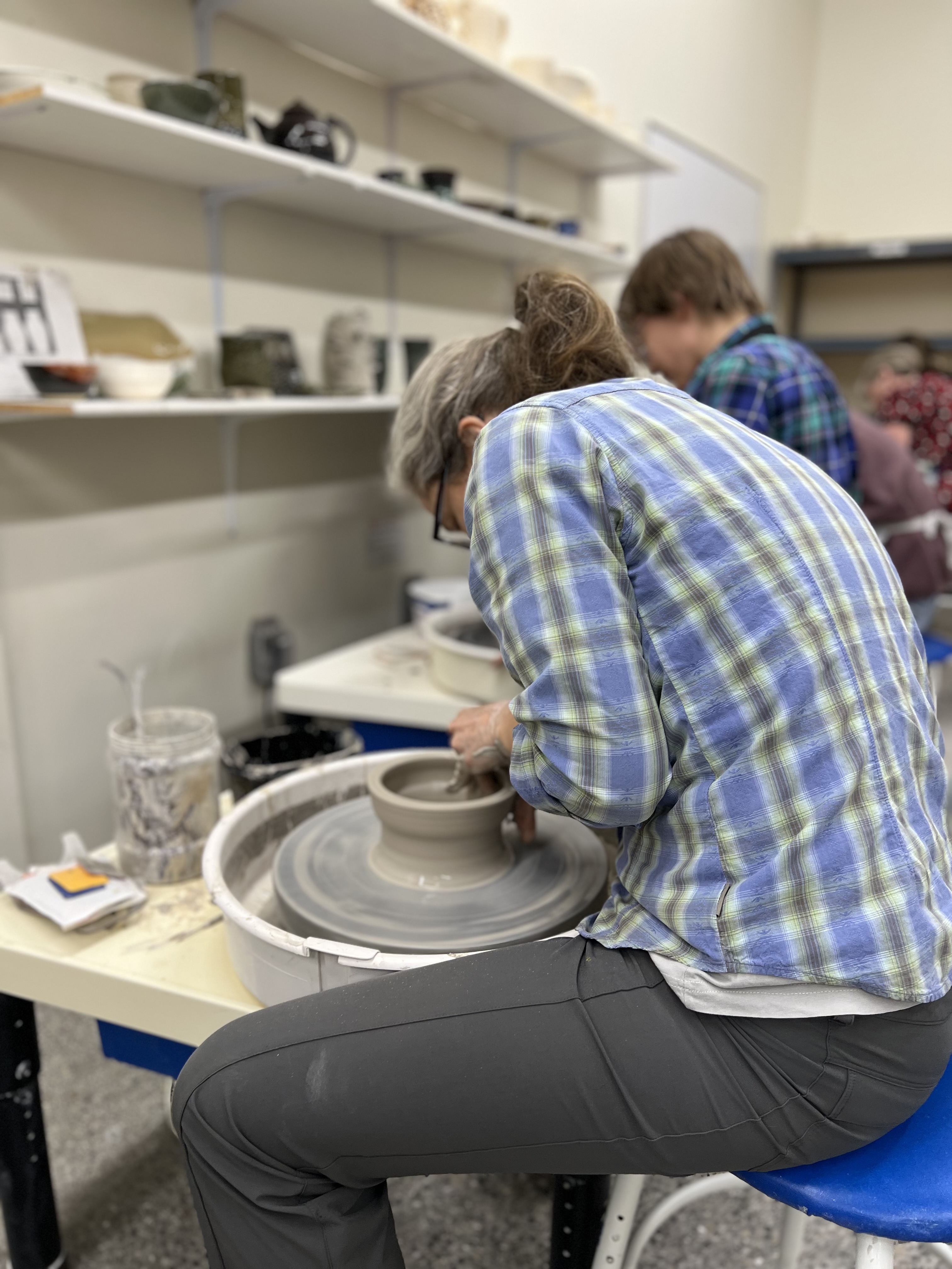 a woman working at the pottery wheel