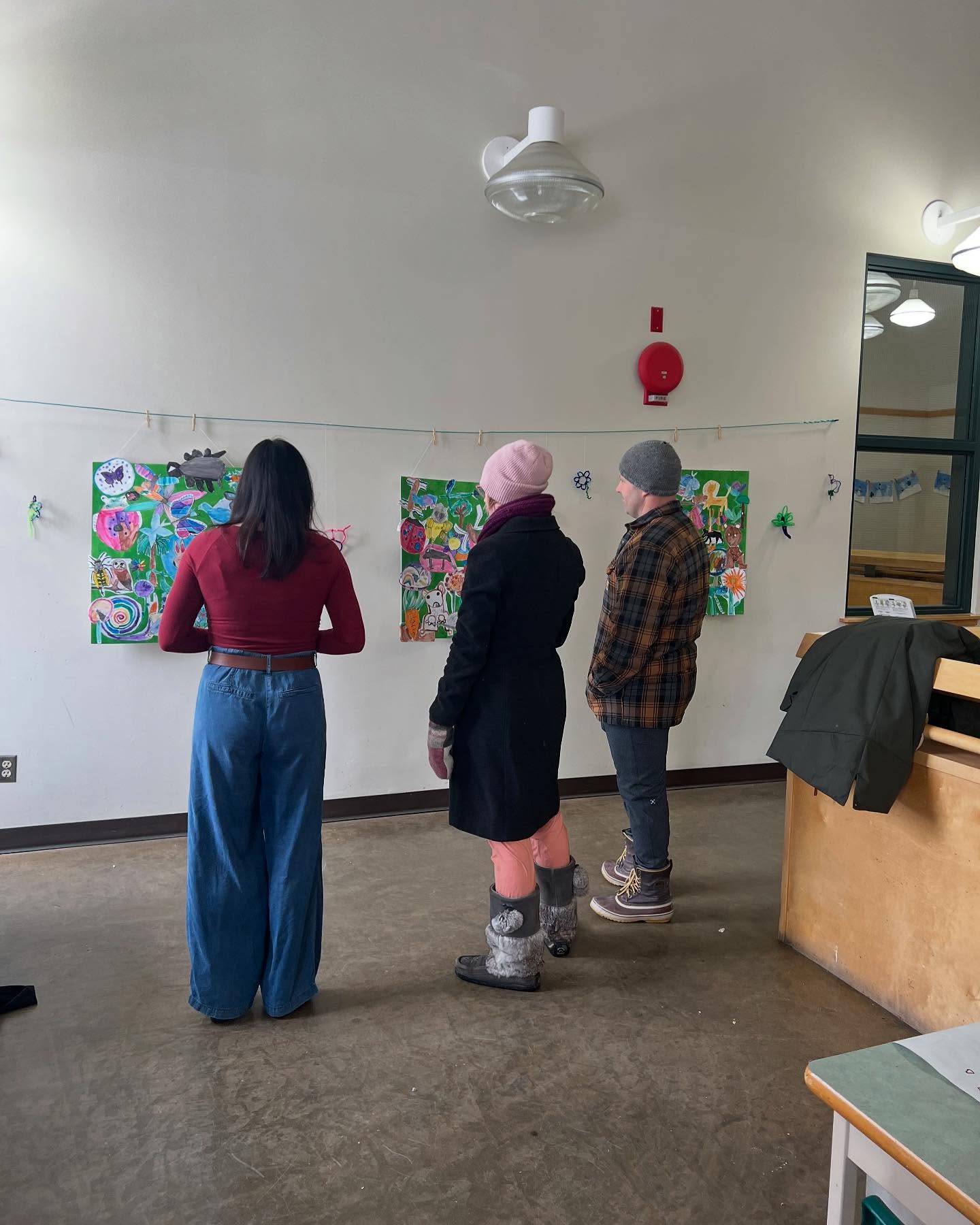 parents look at the artwork during the exhibition opening