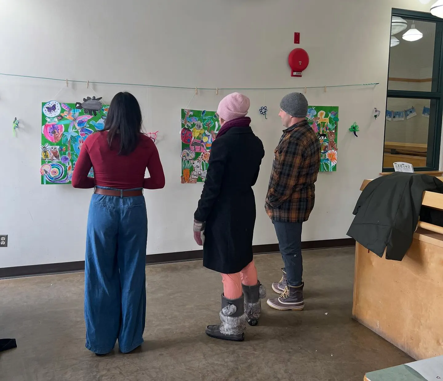 parents look at the artwork during the exhibition opening