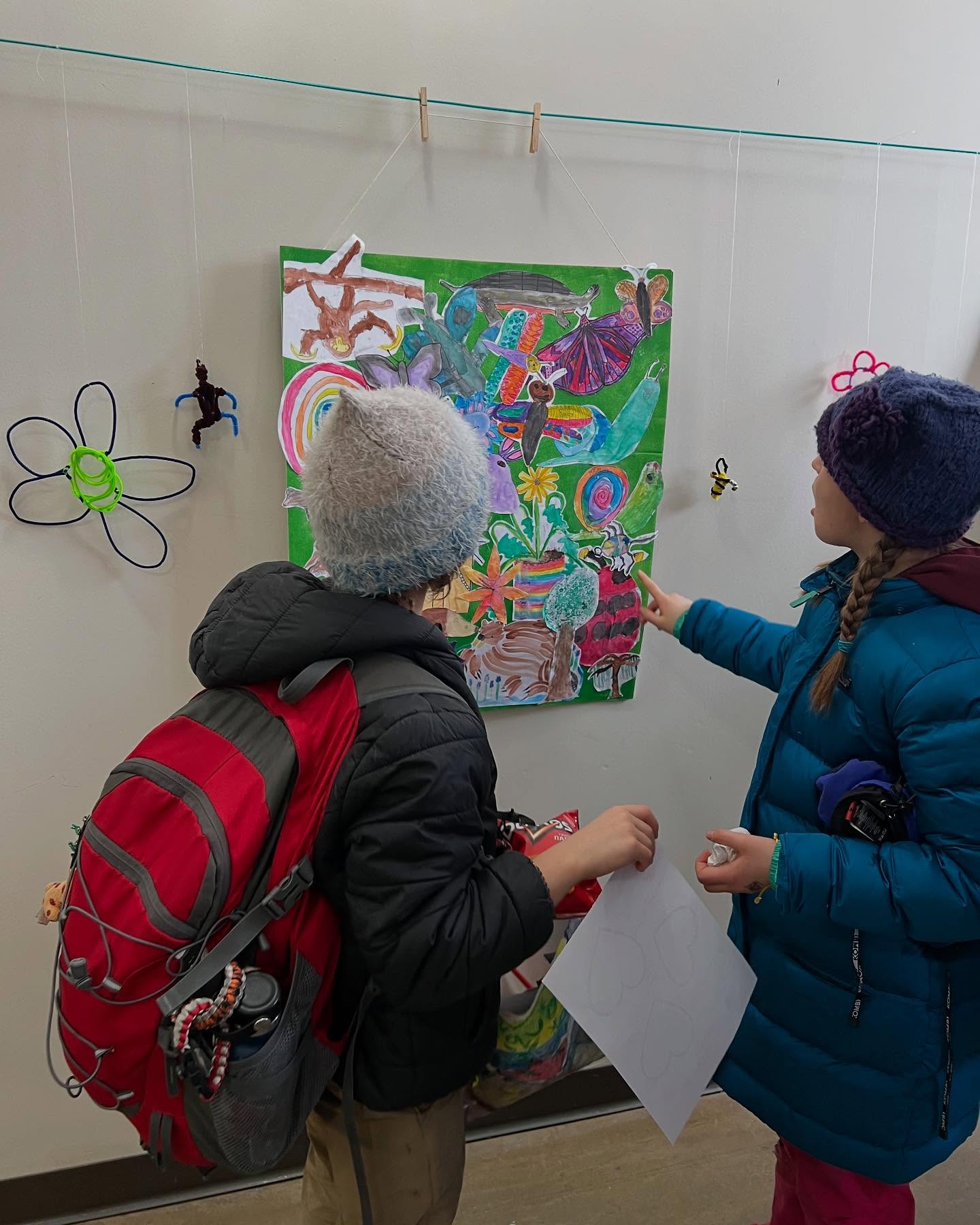 kids look at their art during the exhibition opening