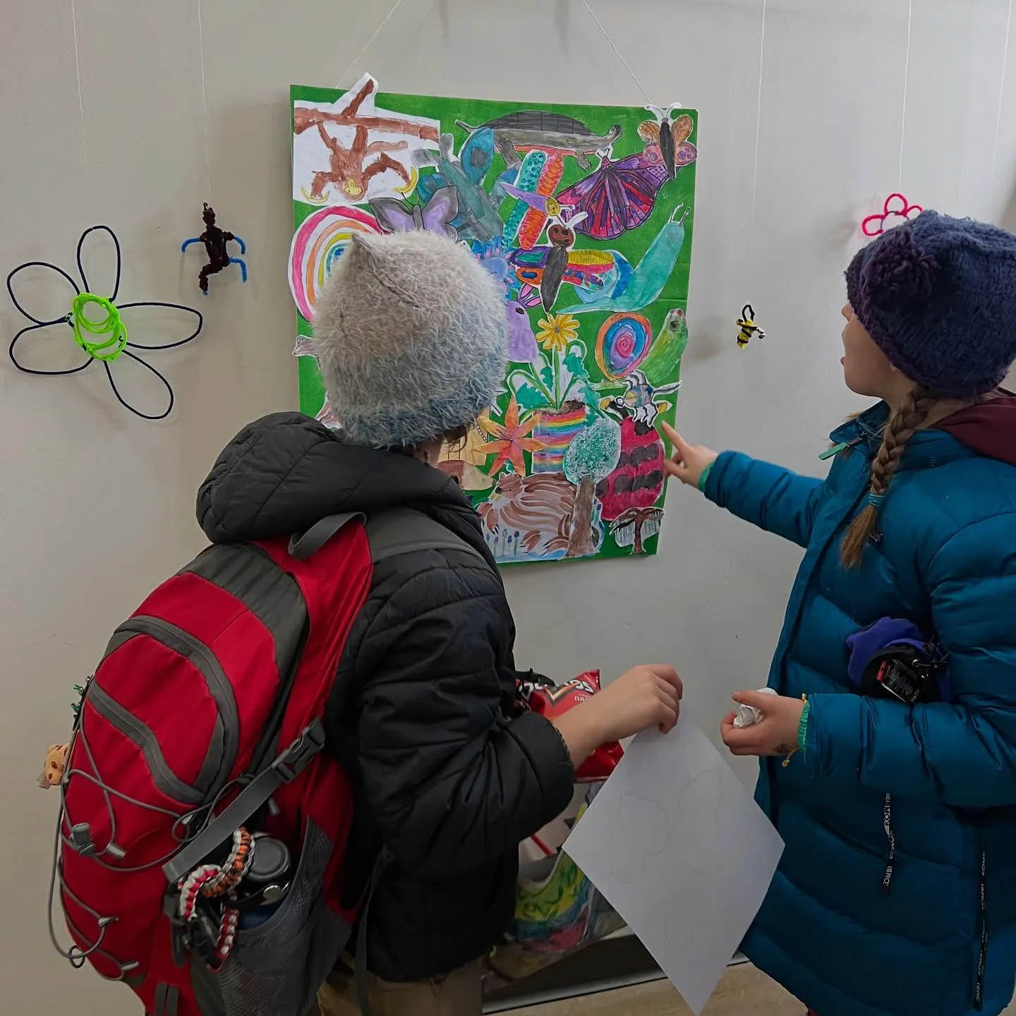 kids look at their art during the exhibition opening