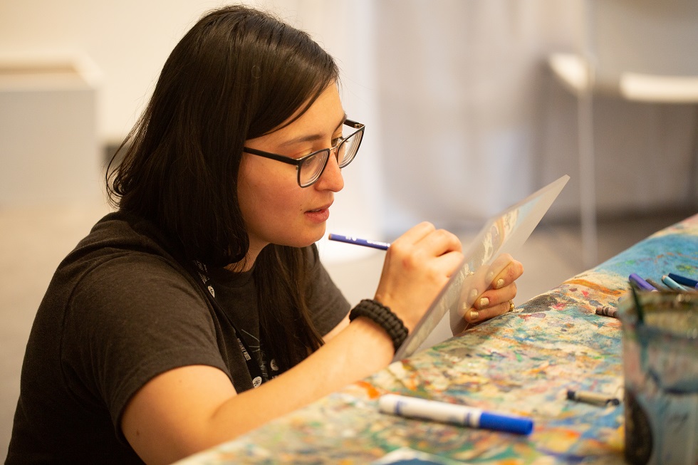a woman painting at the table