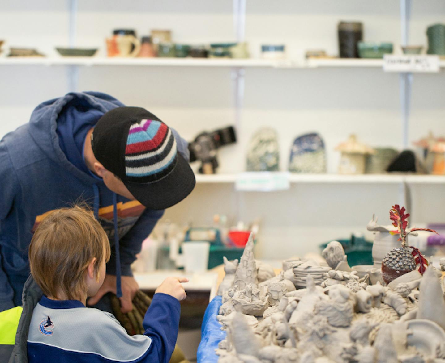 father and son looking at pottery