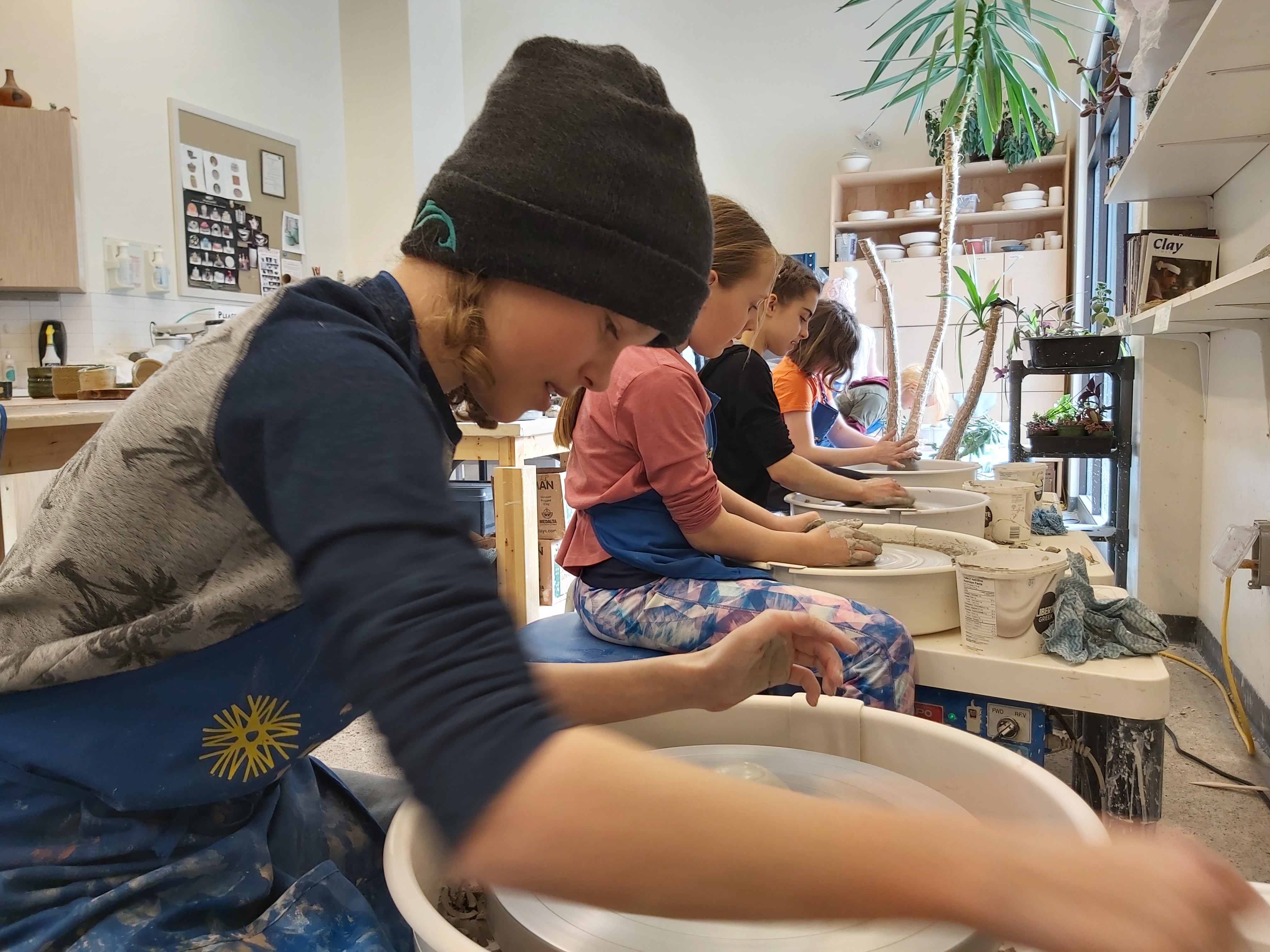 kids working on the pottery wheel