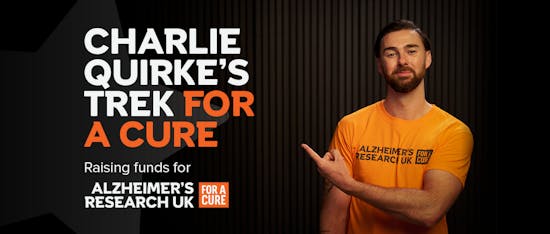 Charlie Quirke pointing to text that reads, Charlie Quirke's trek for a cure, raising funds for Alzheimer's Research UK.