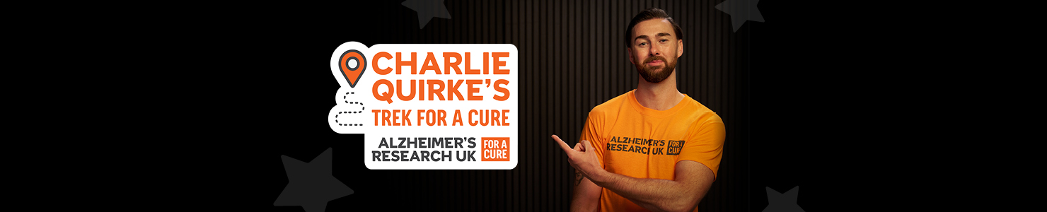 Charlie Quirke pointing to text that reads, Charlie Quirke's trek for a cure, Alzheimer's Research UK.