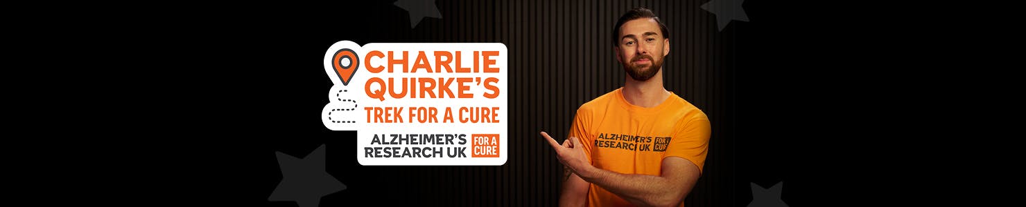 Charlie Quirke pointing to text that reads, Charlie Quirke's trek for a cure, Alzheimer's Research UK.