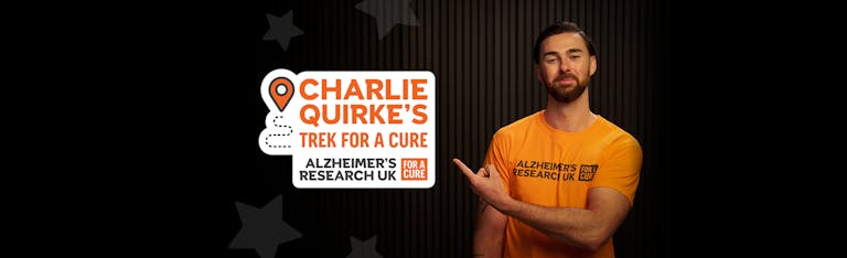Charlie Quirke pointing to text that reads, Charlie Quirke's trek for a cure, Alzheimer's Research UK.
