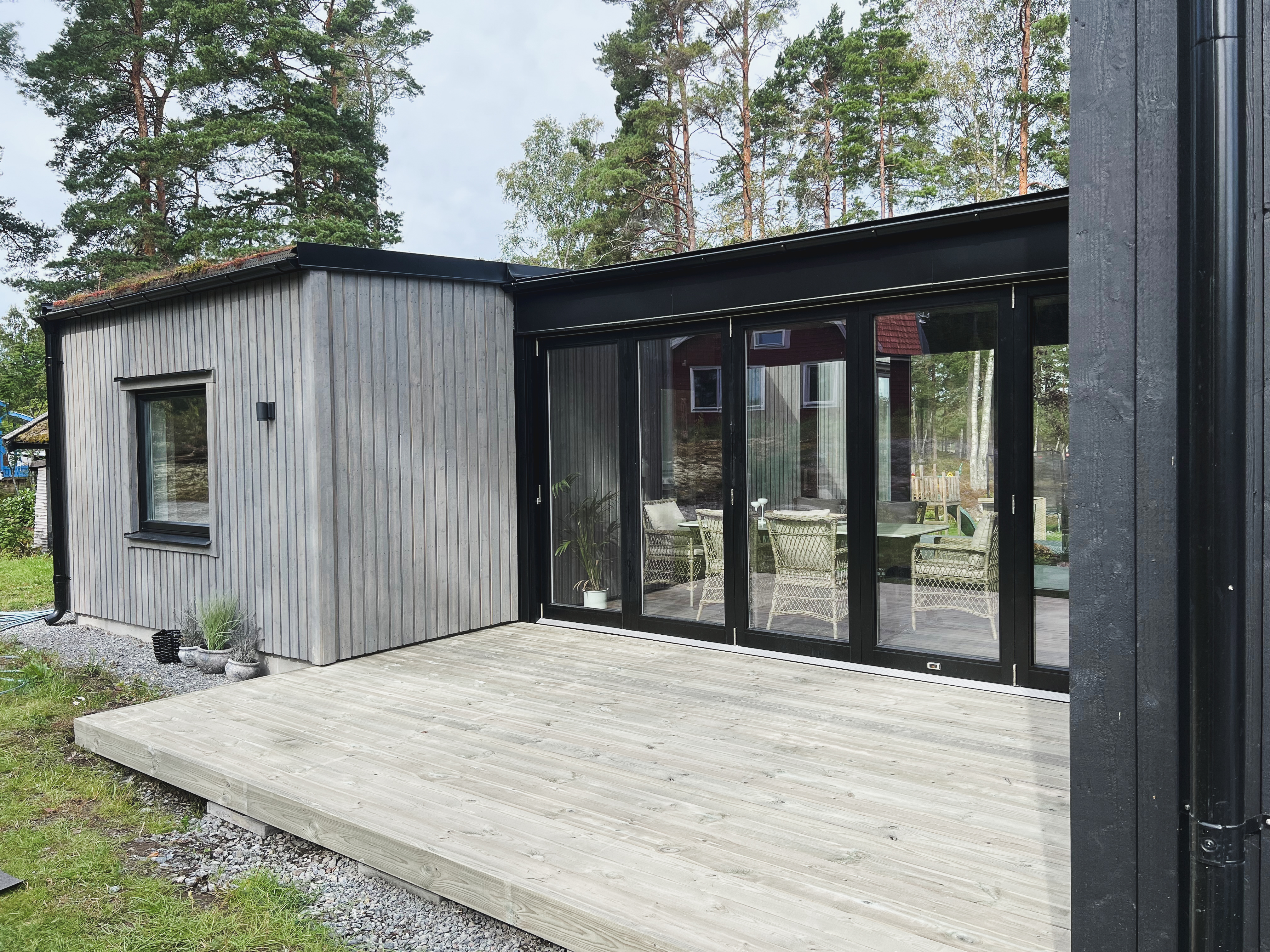 Glasad gång som kopplar samman gästhus med huvudbyggnaden, ritad av arkitektkontor i Stockholm.