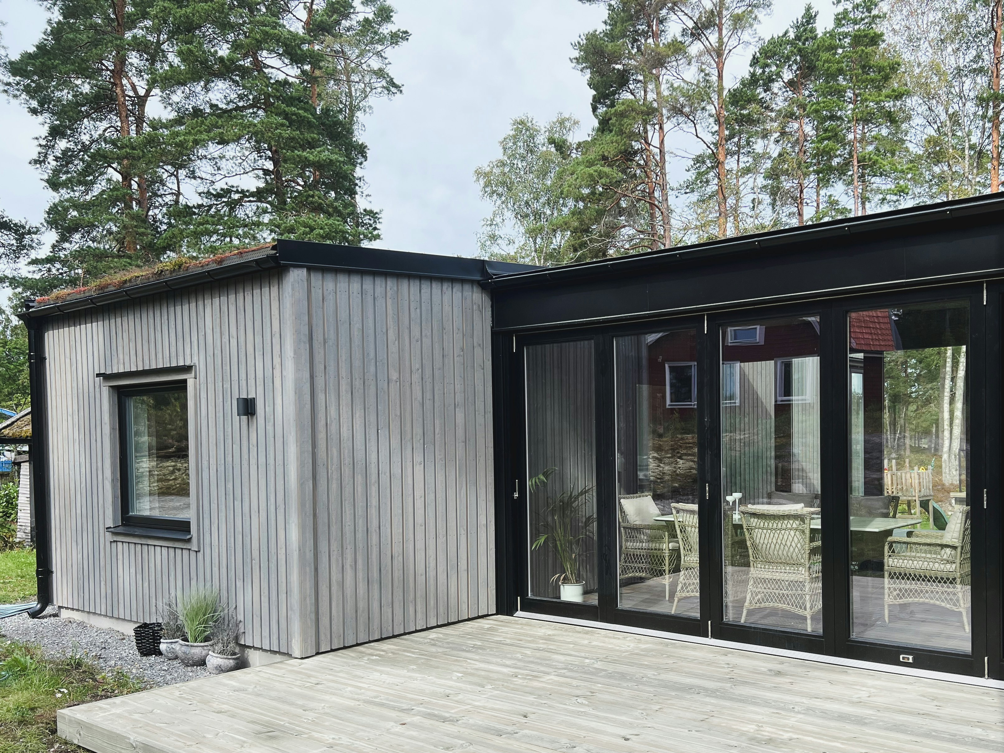 Glasad gång som kopplar samman gästhus med huvudbyggnaden, ritad av arkitektkontor i Stockholm.