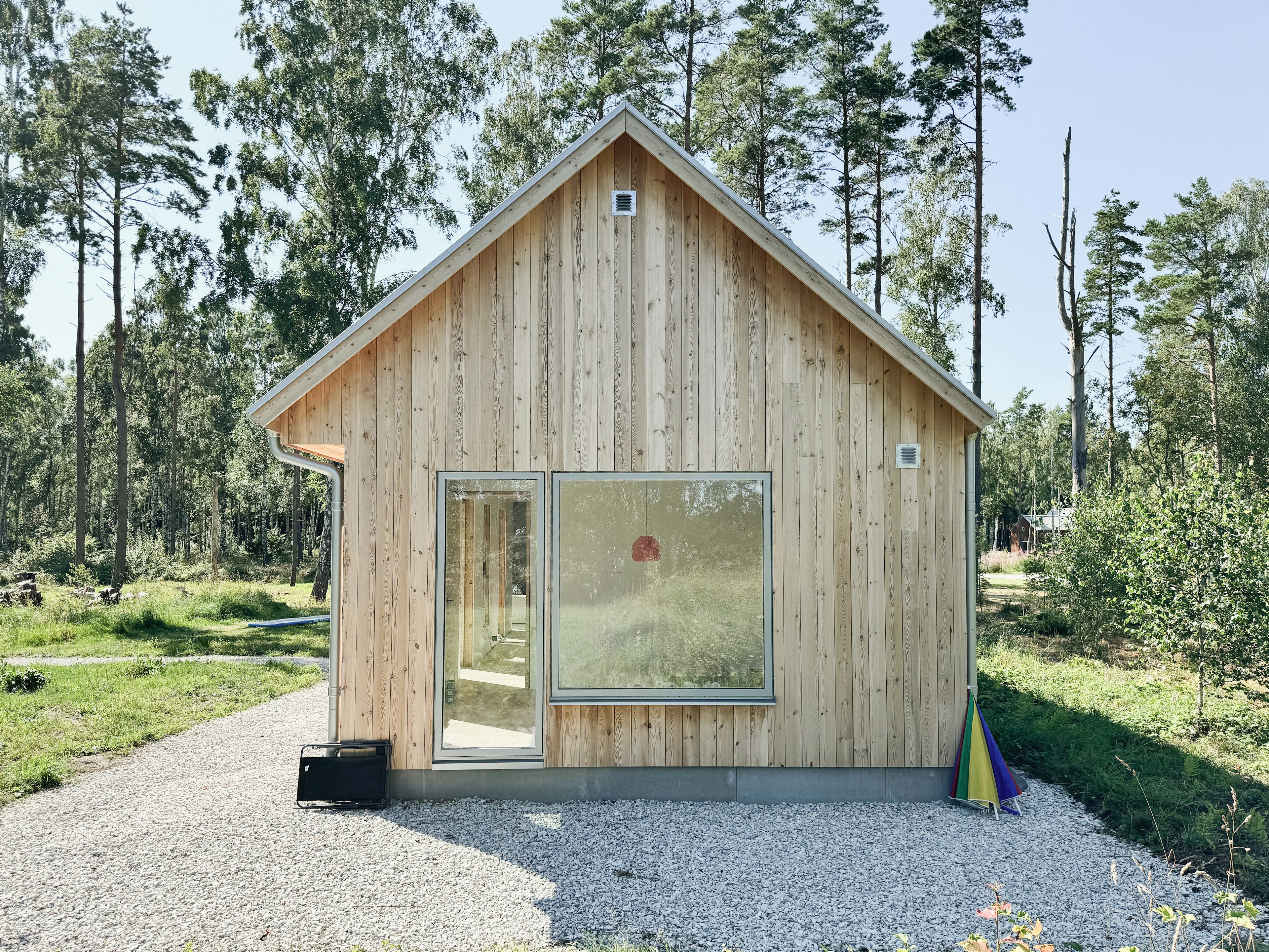 Villa Wendborg – träfasad och stora fönster som släpper in ljus och ramar in naturen.