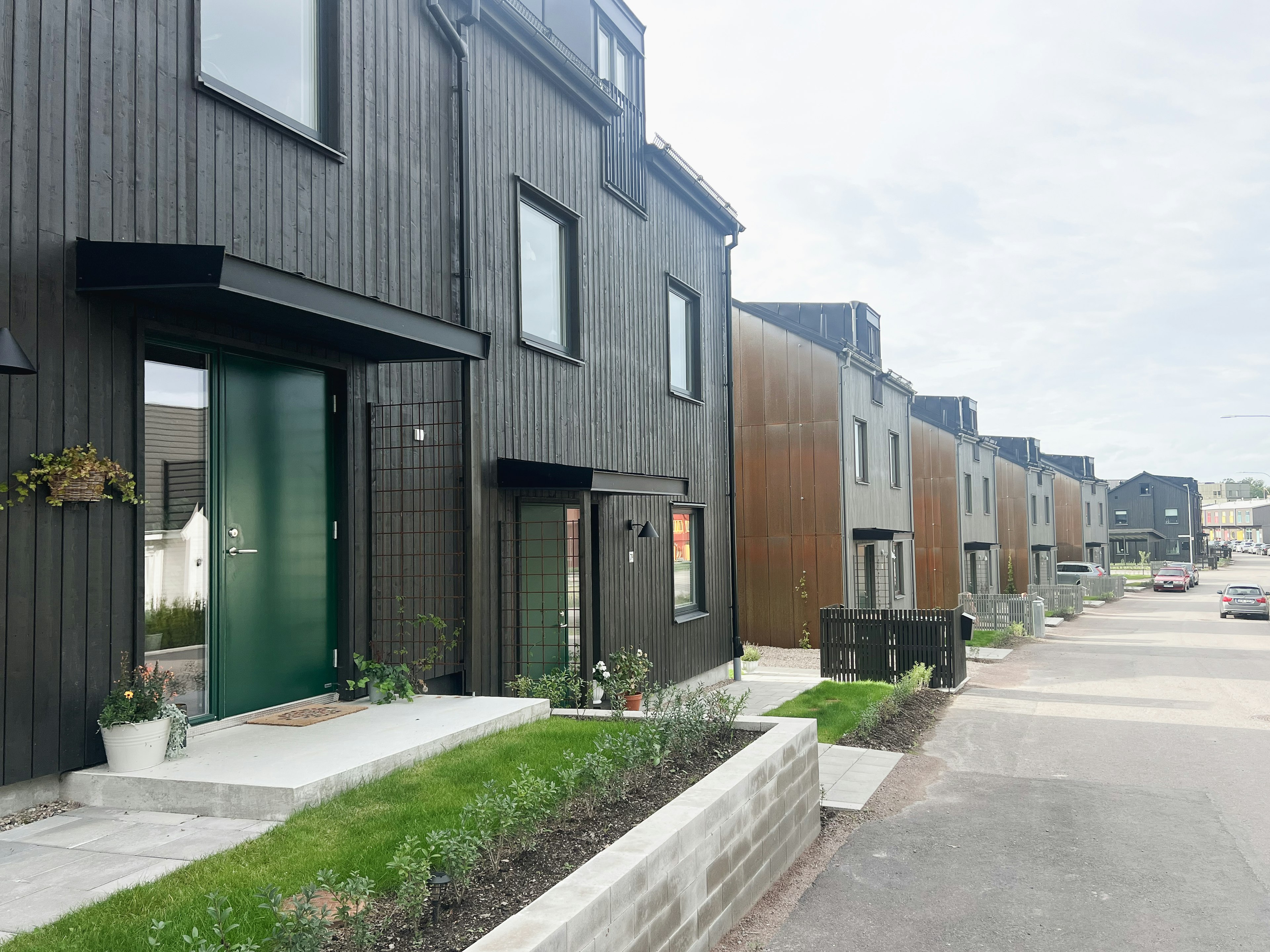 Moderna trähus i Vallhusen Hjulsbro, ett bostadsområde där arkitektur, gemenskap och hållbarhet samspelar.