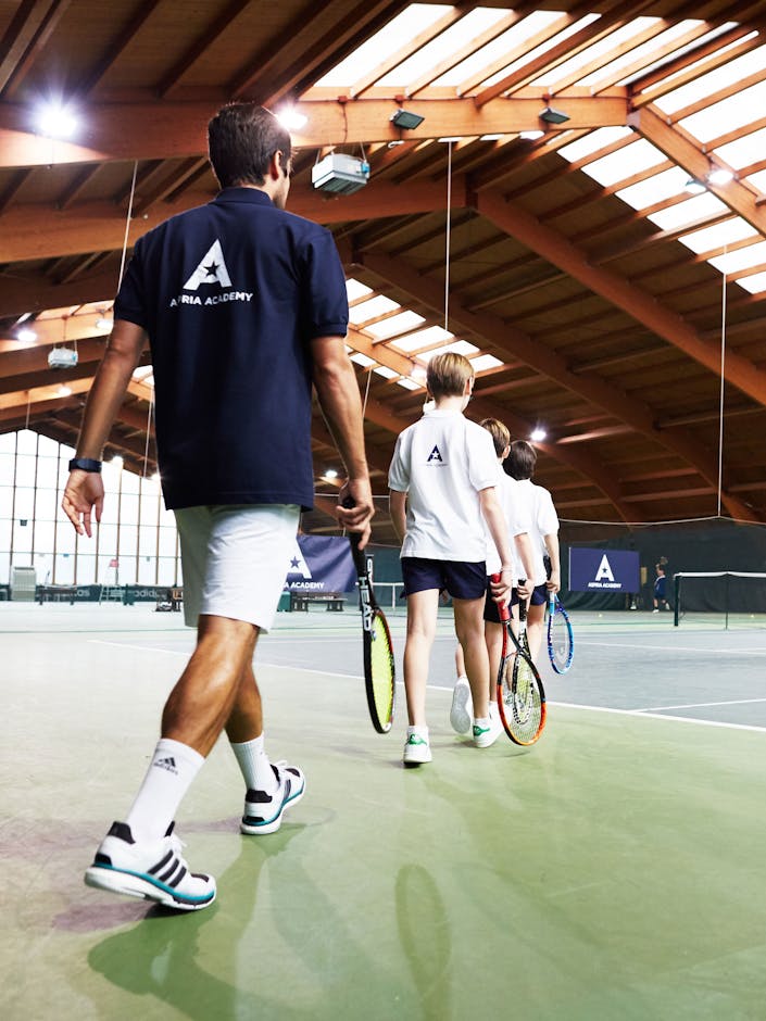 Coach walking out onto indoor tennis courts 