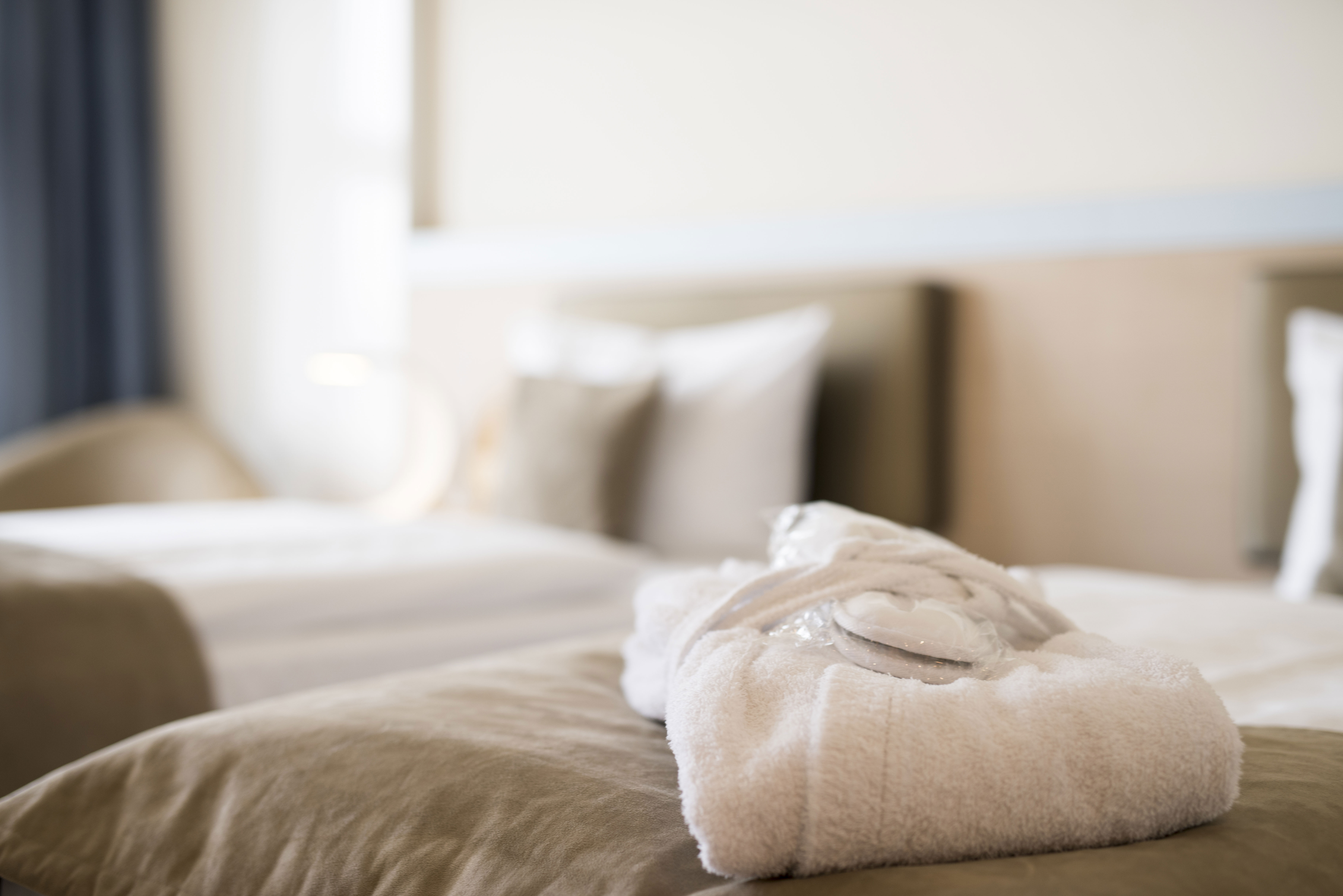 White folded towel sat on top of hotel bed